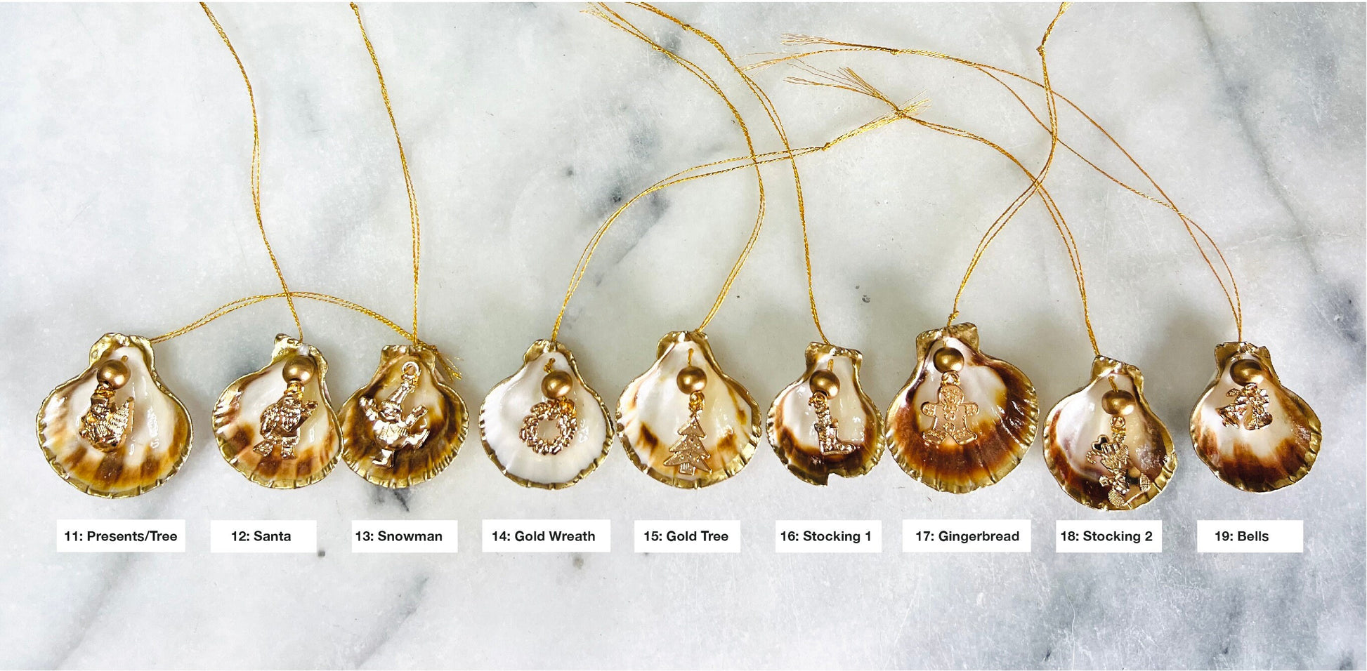 Handmade scallop shell Christmas ornaments with gold leaf edging and enamel charms, natural pearl shell decorations, Dorset shell baubles, festive tree decorations, stocking filler gifts, coastal Christmas decor, small hanging ornaments with gold string, unique handmade shell keepsake, wreath sleigh tree reindeer bell penguin charms, luxury Christmas gift idea