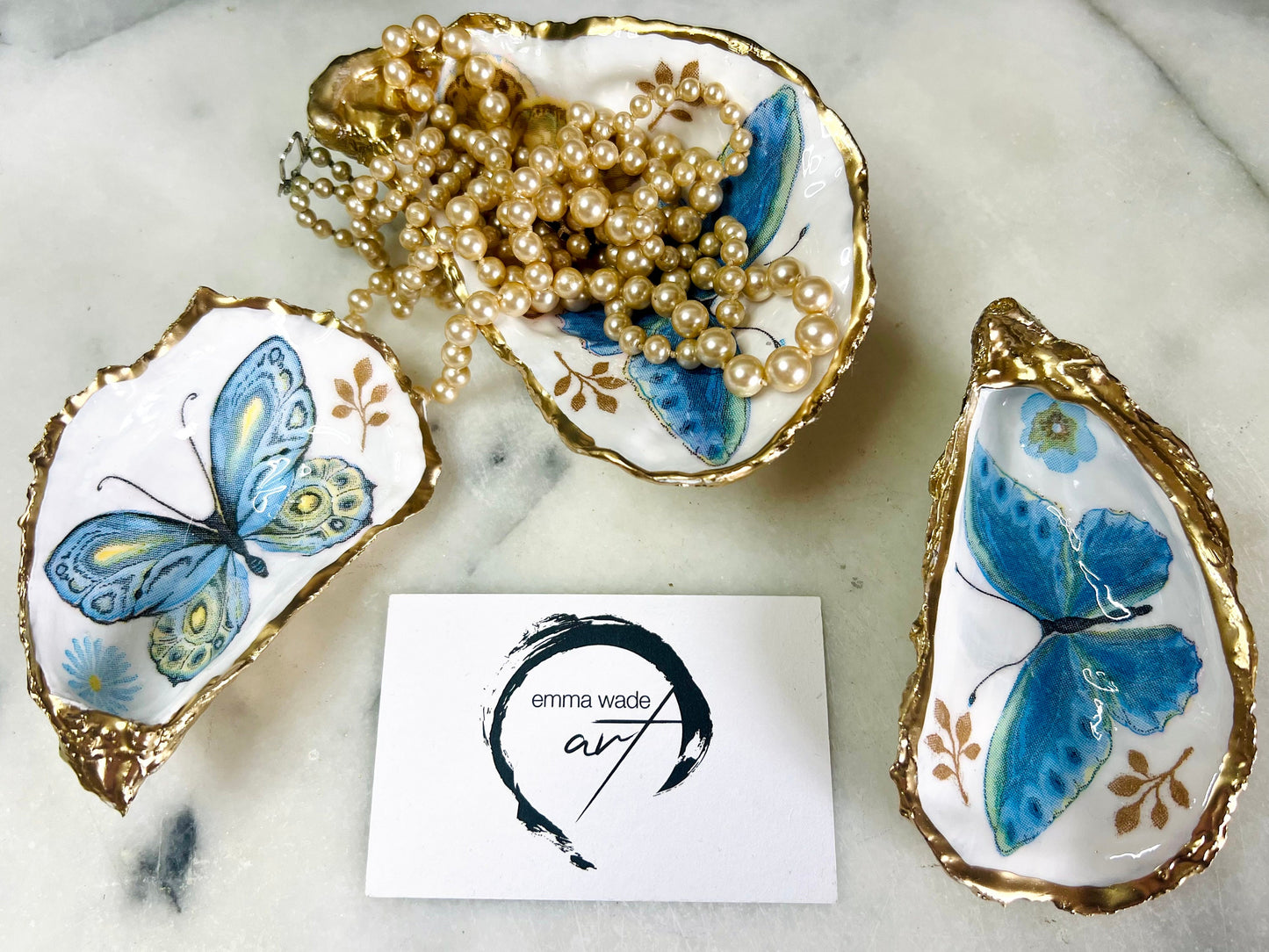 Blue yellow green butterfly oyster shell trinket dish handmade from Dorset coast shell, gold leaf gilded rim and back, high gloss resin interior with colourful butterfly design, coastal home decor jewellery dish, ring holder, trinket tray, seaside gift for her, handmade shell decor, luxury coastal accessory, unique artisan gift UK