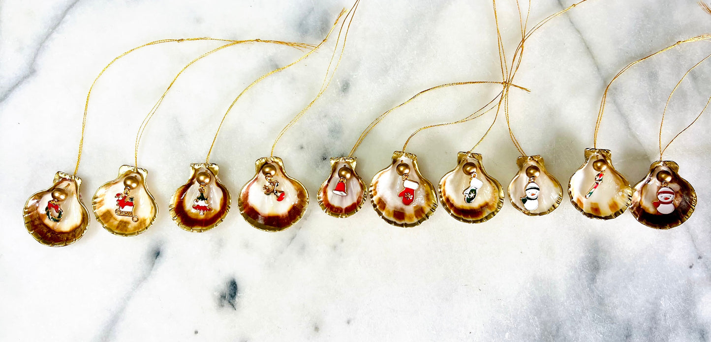 Handmade scallop shell Christmas ornaments with gold leaf edging and enamel charms, natural pearl shell decorations, Dorset shell baubles, festive tree decorations, stocking filler gifts, coastal Christmas decor, small hanging ornaments with gold string, unique handmade shell keepsake, wreath sleigh tree reindeer bell penguin charms, luxury Christmas gift idea