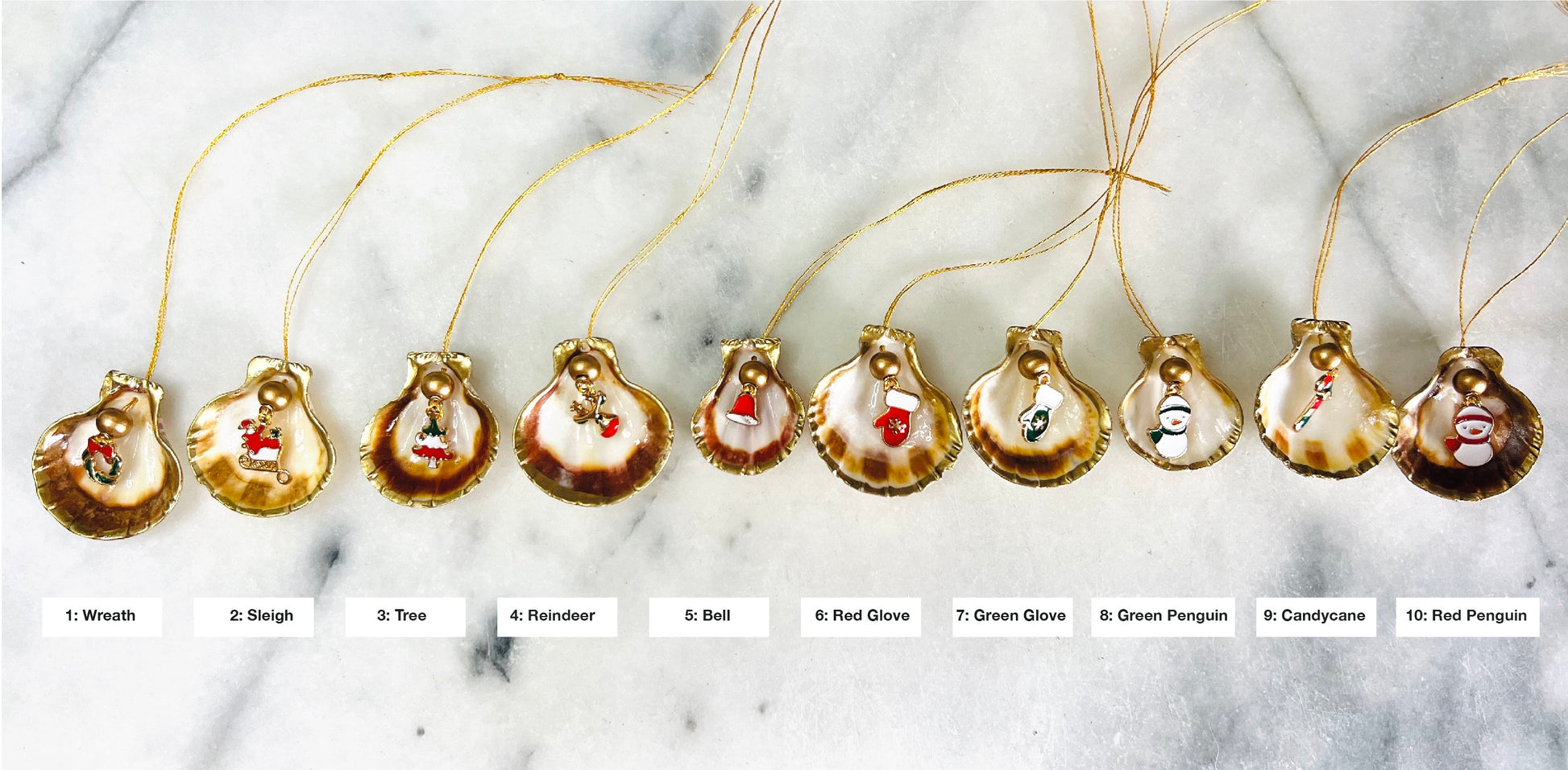 Handmade scallop shell Christmas ornaments with gold leaf edging and enamel charms, natural pearl shell decorations, Dorset shell baubles, festive tree decorations, stocking filler gifts, coastal Christmas decor, small hanging ornaments with gold string, unique handmade shell keepsake, wreath sleigh tree reindeer bell penguin charms, luxury Christmas gift idea