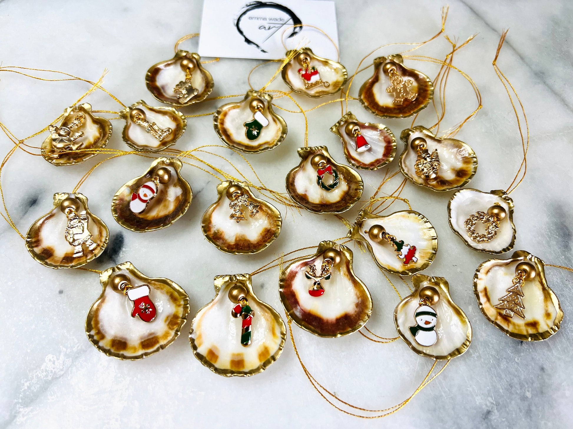 Handmade scallop shell Christmas ornaments with gold leaf edging and enamel charms, natural pearl shell decorations, Dorset shell baubles, festive tree decorations, stocking filler gifts, coastal Christmas decor, small hanging ornaments with gold string, unique handmade shell keepsake, wreath sleigh tree reindeer bell penguin charms, luxury Christmas gift idea