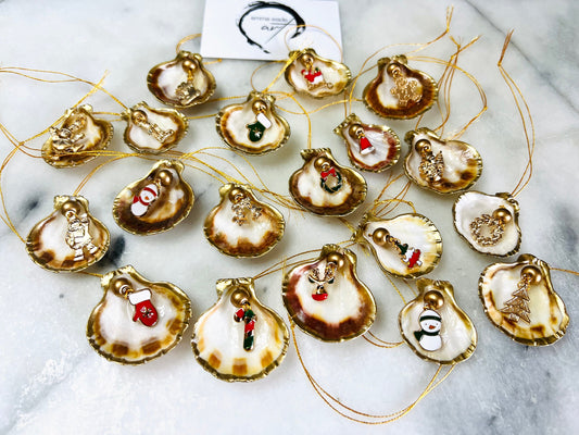 Handmade scallop shell Christmas ornaments with gold leaf edging and enamel charms, natural pearl shell decorations, Dorset shell baubles, festive tree decorations, stocking filler gifts, coastal Christmas decor, small hanging ornaments with gold string, unique handmade shell keepsake, wreath sleigh tree reindeer bell penguin charms, luxury Christmas gift idea