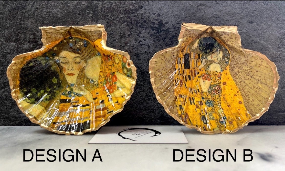 Handmade scallop shell trinket dish inspired by Gustav Klimt’s “The Kiss”, finished with gold leaf and sealed with glossy resin. Coastal Dorset shell jewellery dish perfect for rings, earrings and small treasures. Unique decorative shell bowl with golden artwork design, photographed on a light background showing detailed gilded surface and natural shell shape.