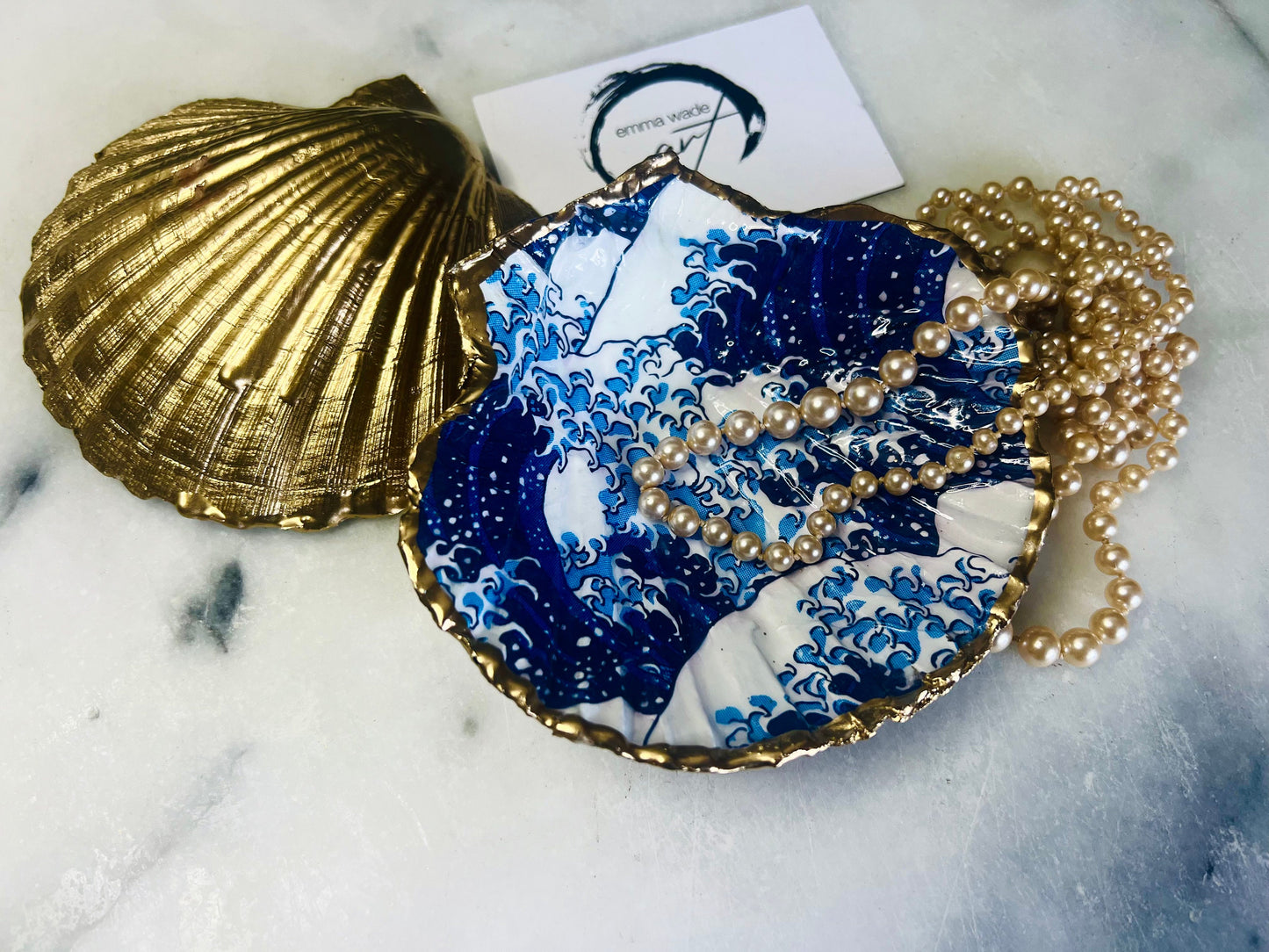 Great Wave of Kanagawa inspired scallop shell trinket dish with deep blue ocean wave artwork, gold leaf edging and glossy resin finish. Handmade coastal jewellery tray and Japanese ocean-inspired ring dish created from a natural Dorset scallop shell.