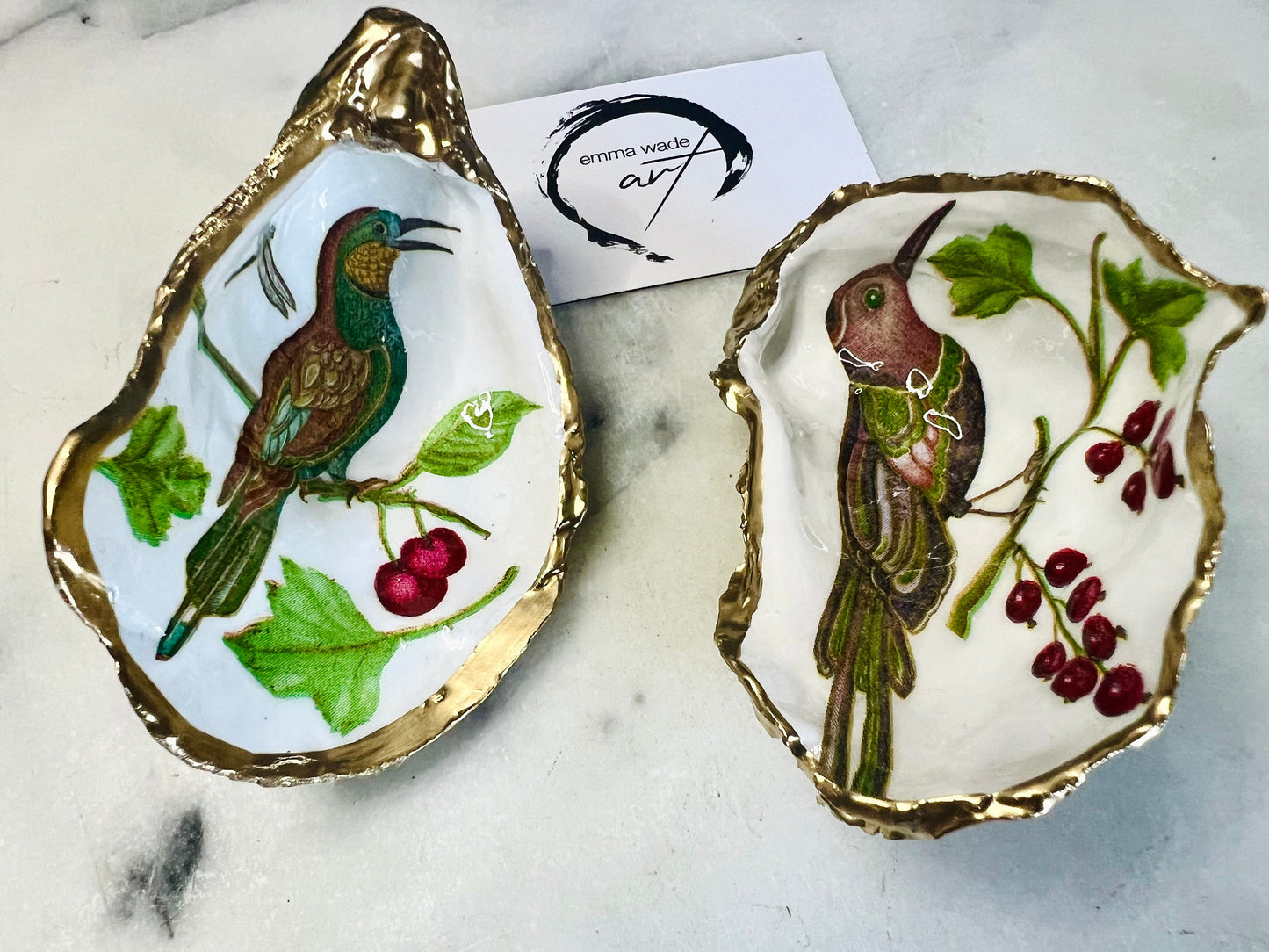 Handmade Dorset oyster shell trinket dish featuring Birds of Paradise illustration with green and brown bird designs, hand gilded with liquid gold leaf on the rim and reverse, sealed with glossy crystal clear resin, coastal jewellery holder, botanical bird decor, nature inspired oyster shell gift UK