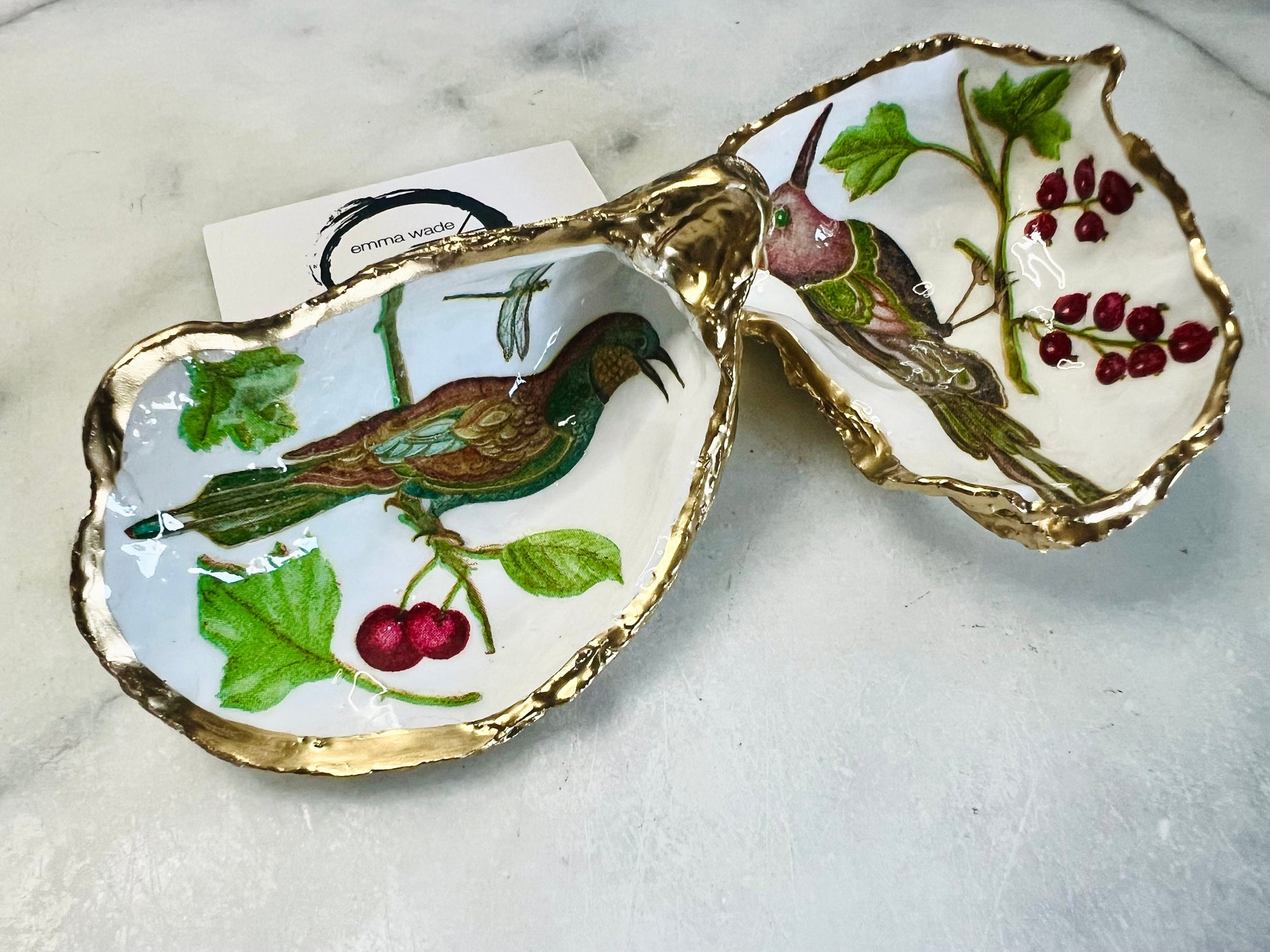 Handmade Dorset oyster shell trinket dish featuring Birds of Paradise illustration with green and brown bird designs, hand gilded with liquid gold leaf on the rim and reverse, sealed with glossy crystal clear resin, coastal jewellery holder, botanical bird decor, nature inspired oyster shell gift UK