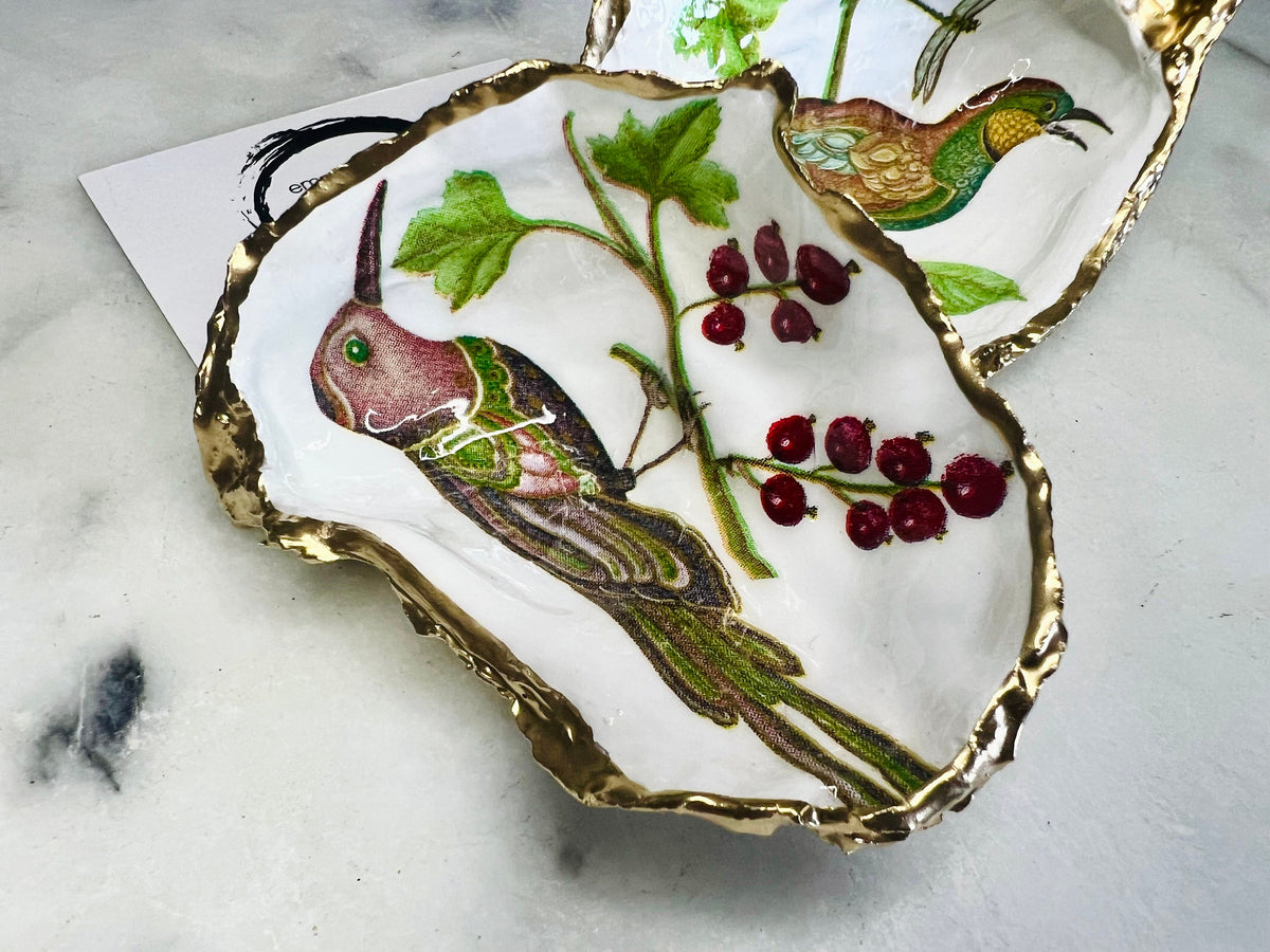Birds of Paradise Dorset oyster shell dish, handmade and finished with real gold leaf. Two design options: green bird or brown bird. Perfect as a jewellery dish, trinket dish, ring holder, tea light holder, salt and pepper pinch pot, or decorative coastal ornament. Eco-friendly, sustainable, and inspired by the Dorset coast. A unique handmade UK gift for weddings, anniversaries, birthdays, Christmas, or coastal home décor.