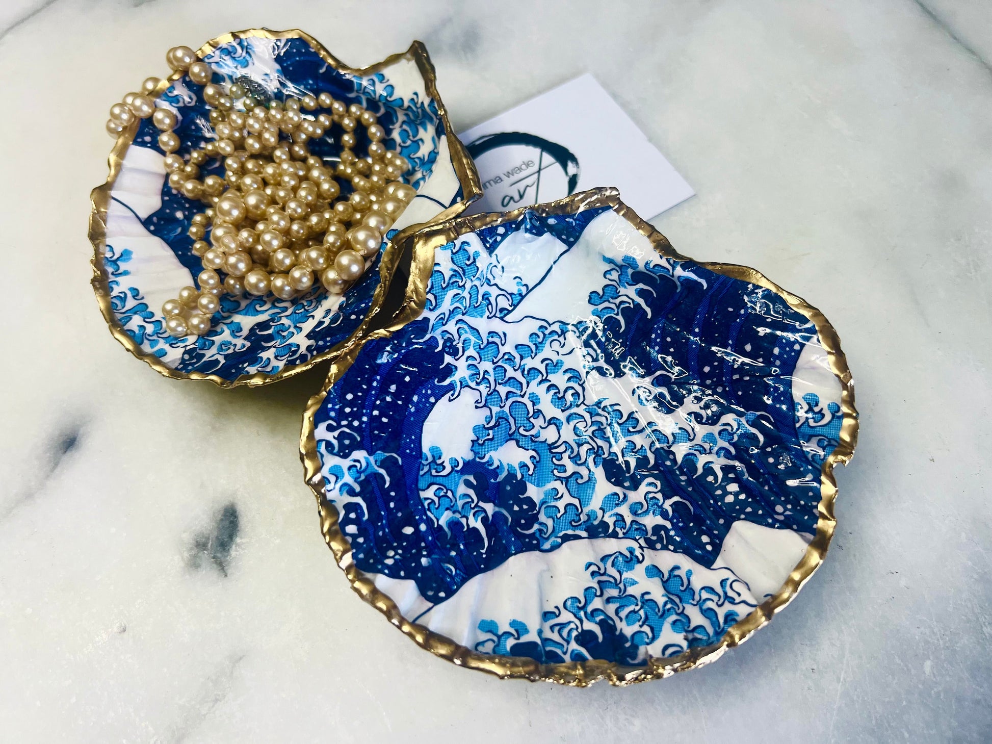 Great Wave of Kanagawa inspired scallop shell trinket dish with deep blue ocean wave artwork, gold leaf edging and glossy resin finish. Handmade coastal jewellery tray and Japanese ocean-inspired ring dish created from a natural Dorset scallop shell.