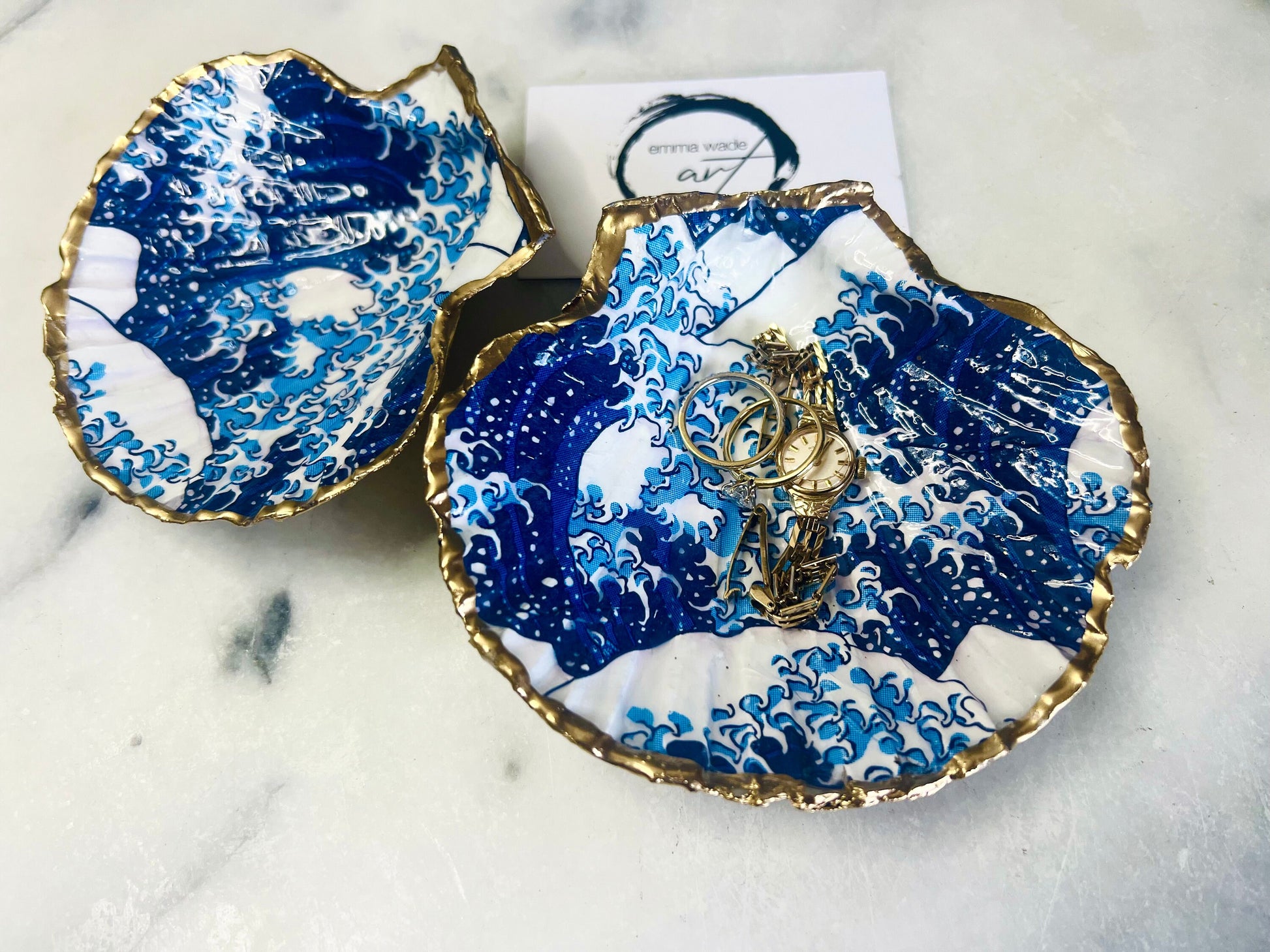Great Wave of Kanagawa inspired scallop shell trinket dish with deep blue ocean wave artwork, gold leaf edging and glossy resin finish. Handmade coastal jewellery tray and Japanese ocean-inspired ring dish created from a natural Dorset scallop shell.