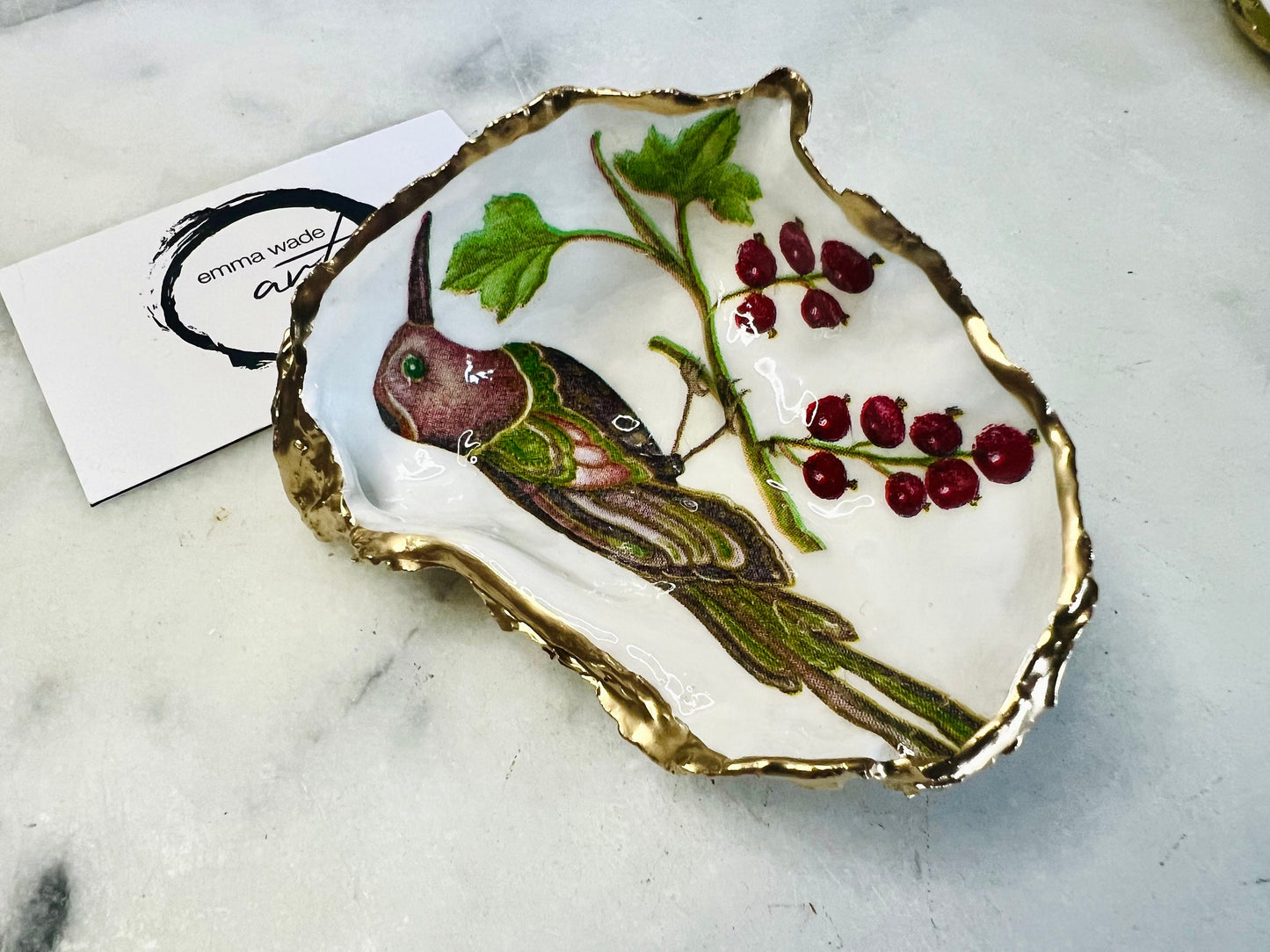 Handmade Dorset oyster shell trinket dish featuring Birds of Paradise illustration with green and brown bird designs, hand gilded with liquid gold leaf on the rim and reverse, sealed with glossy crystal clear resin, coastal jewellery holder, botanical bird decor, nature inspired oyster shell gift UK
