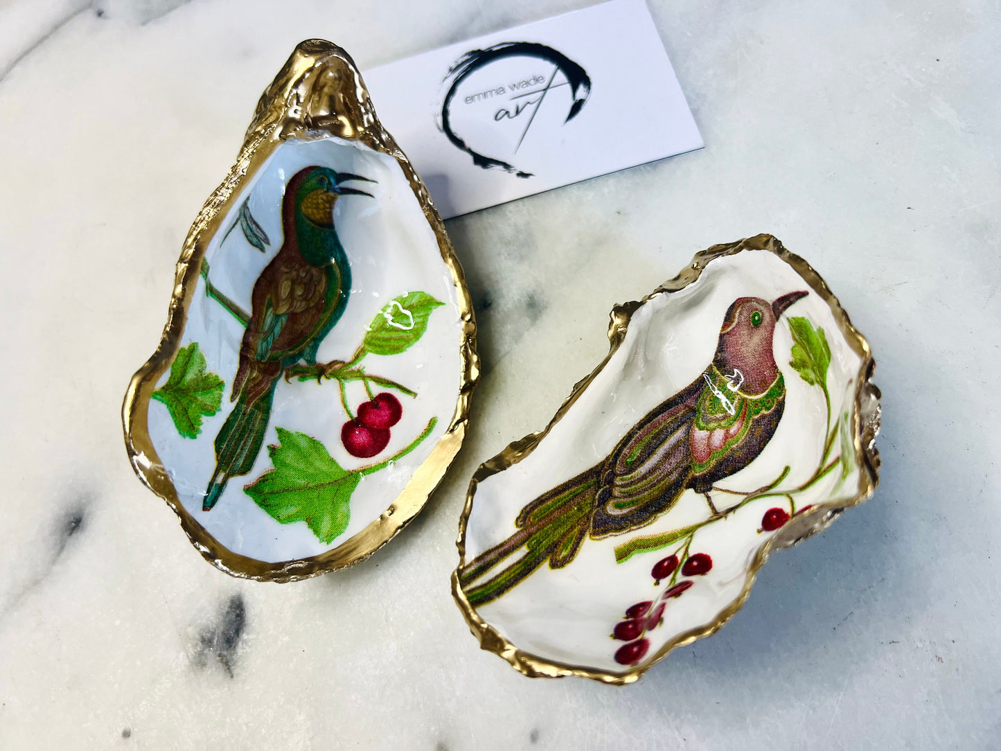 Handmade Dorset oyster shell trinket dish featuring Birds of Paradise illustration with green and brown bird designs, hand gilded with liquid gold leaf on the rim and reverse, sealed with glossy crystal clear resin, coastal jewellery holder, botanical bird decor, nature inspired oyster shell gift UK