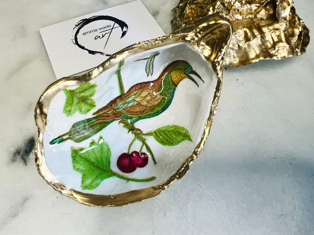 Birds of Paradise Dorset oyster shell dish, handmade and finished with real gold leaf. Two design options: green bird or brown bird. Perfect as a jewellery dish, trinket dish, ring holder, tea light holder, salt and pepper pinch pot, or decorative coastal ornament. Eco-friendly, sustainable, and inspired by the Dorset coast. A unique handmade UK gift for weddings, anniversaries, birthdays, Christmas, or coastal home décor.