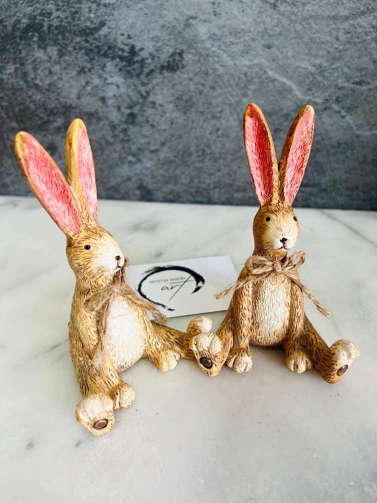 Hand finished brown Christmas rabbit ornament with soft pink inner ears and a rustic jute bow. Single resin bunny decoration sold individually, styled as festive shelf decor for a mantelpiece, console table or woodland Christmas display. Rustic country home ornament and Christmas gift for rabbit lovers.