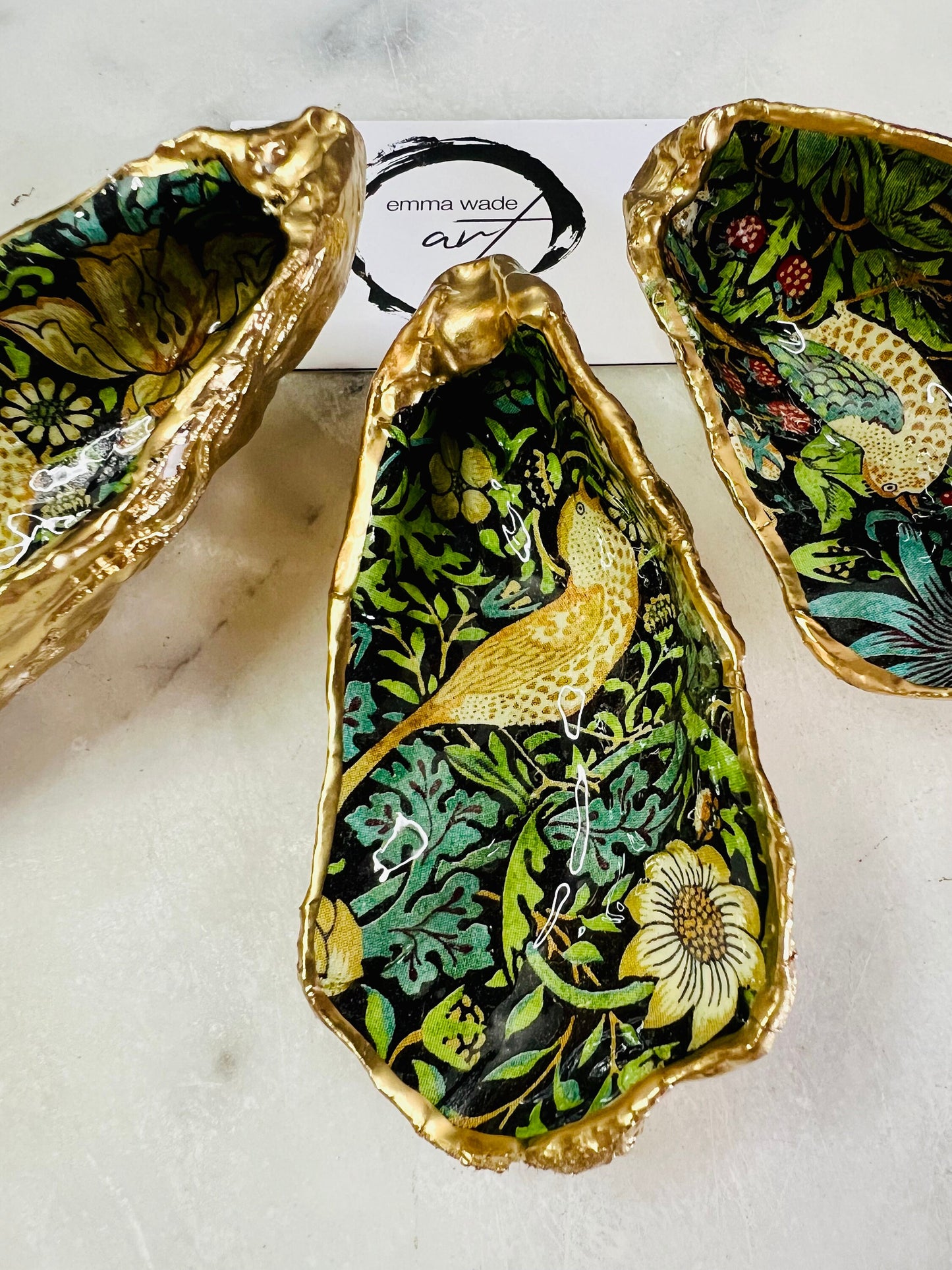 Handcrafted William Morris Strawberry Thief oyster shell dish. Gilded with real gold leaf and finished with glossy resin. Two designs available. Ideal as a jewellery dish, trinket holder, cufflink or tie pin dish, tea light holder, or salt and pepper pinch pot. Sustainable coastal décor, UK handmade shell ornament, unique gift for weddings, birthdays, anniversaries, or Christmas.