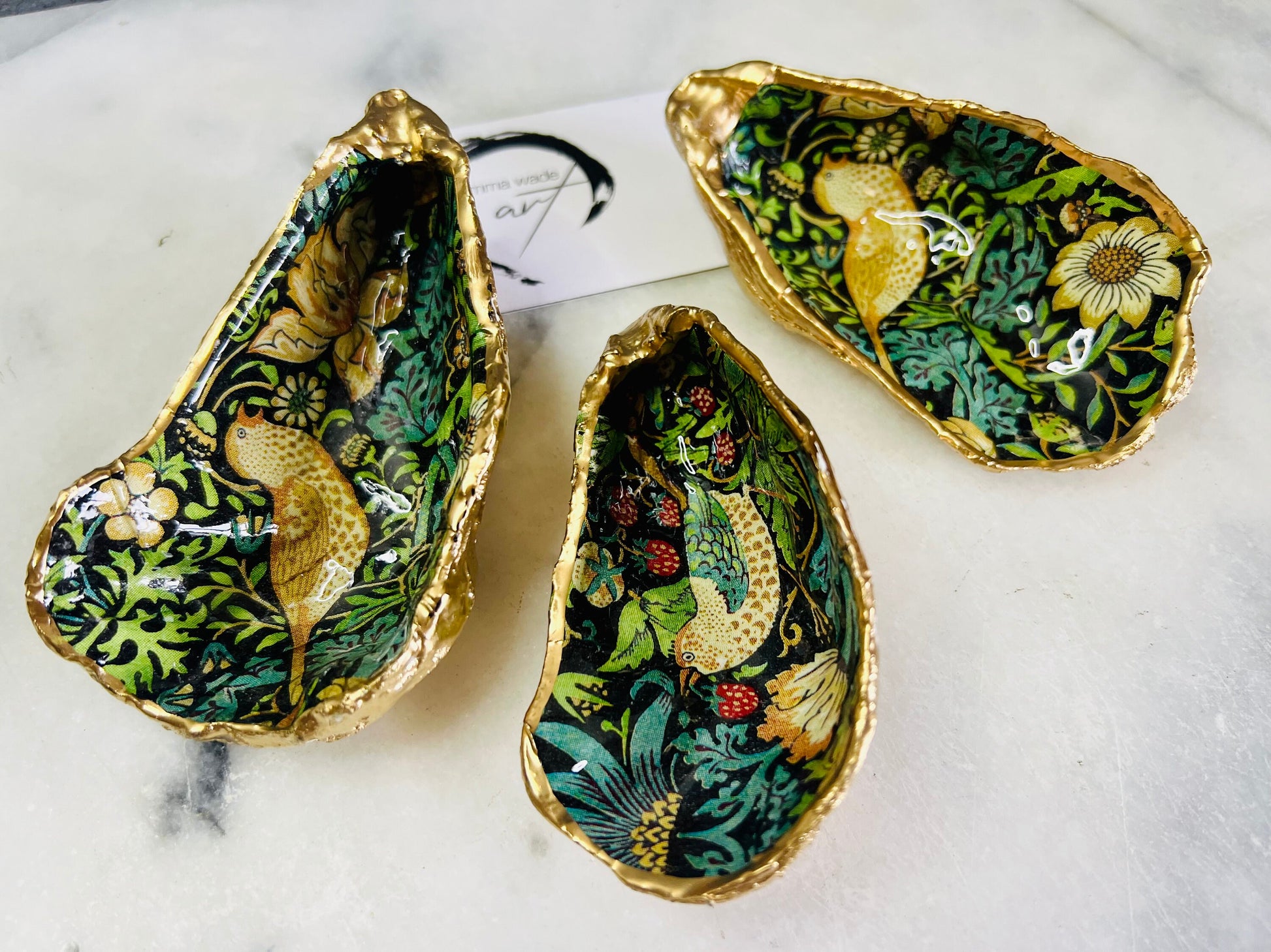 Handcrafted William Morris Strawberry Thief oyster shell dish. Gilded with real gold leaf and finished with glossy resin. Two designs available. Ideal as a jewellery dish, trinket holder, cufflink or tie pin dish, tea light holder, or salt and pepper pinch pot. Sustainable coastal décor, UK handmade shell ornament, unique gift for weddings, birthdays, anniversaries, or Christmas.