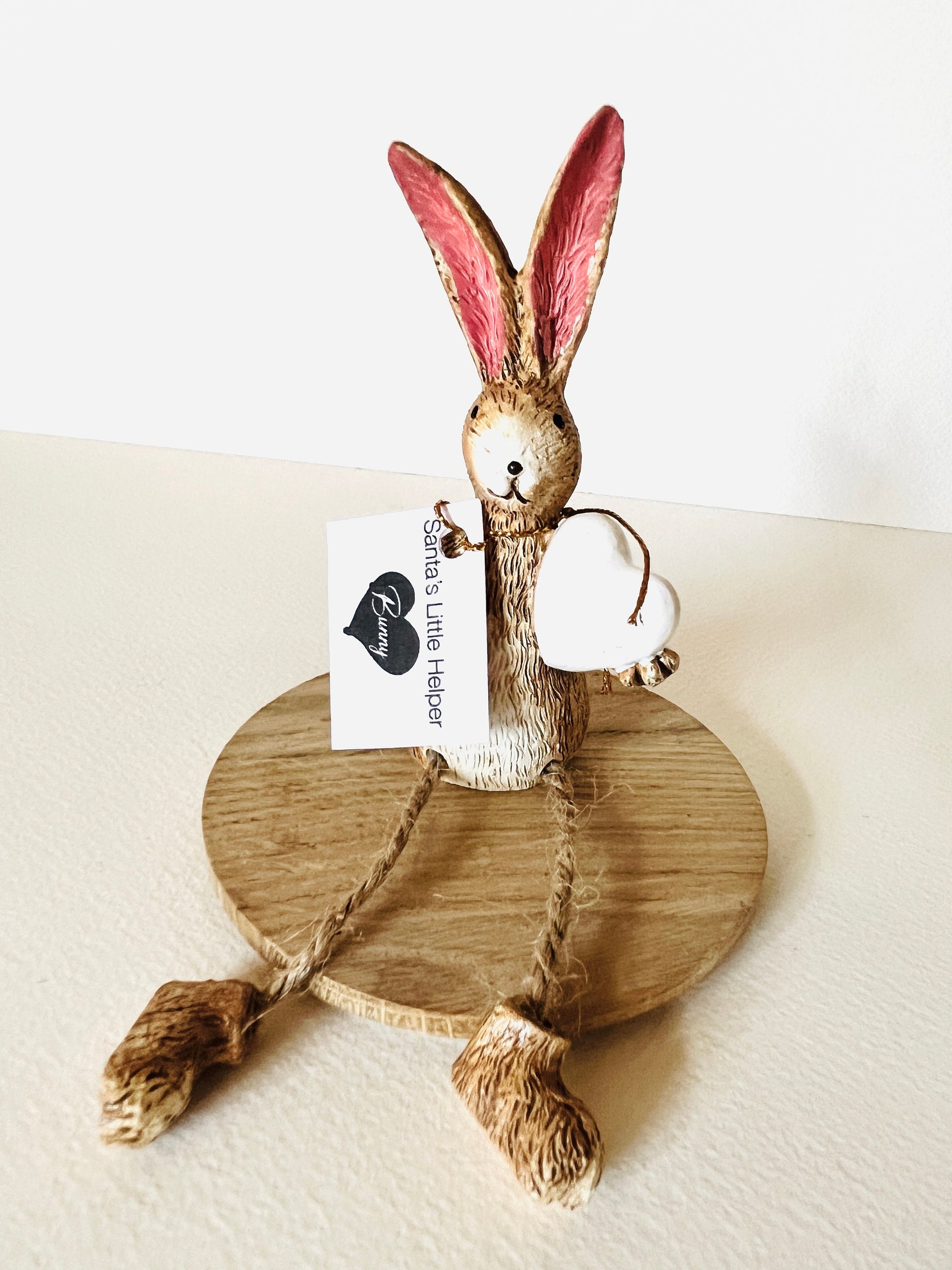 Rustic brown bunny shelf sitter with white heart and dangling jute legs, hand finished polyresin rabbit ornament for spring and cottage style home decor. Perfect Mother’s Day gift or a gift for her.
