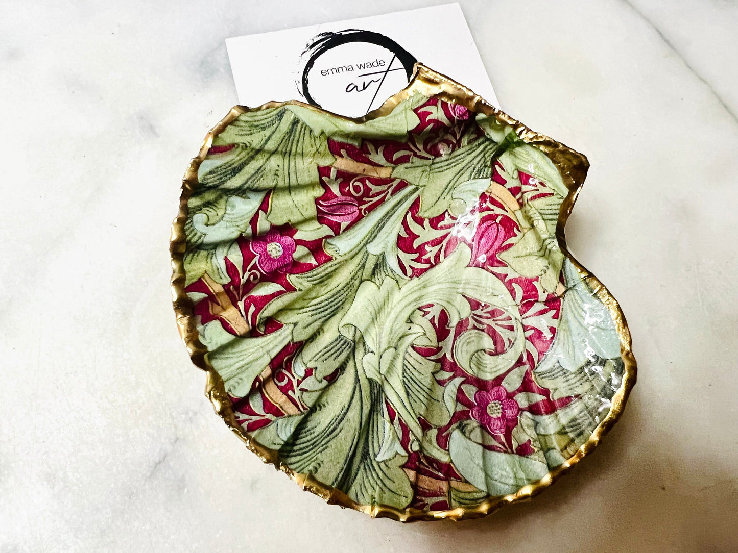 Handmade Dorset scallop shell trinket dish featuring William Morris Granville Bordeaux pattern, finished with real gold leaf edging and a glossy resin coating. A sustainable coastal jewellery dish and ring holder, individually handcrafted in the UK. Ideal as a unique gift for her, wedding or anniversary present, or elegant home décor accent inspired by nature and classic Arts and Crafts design.