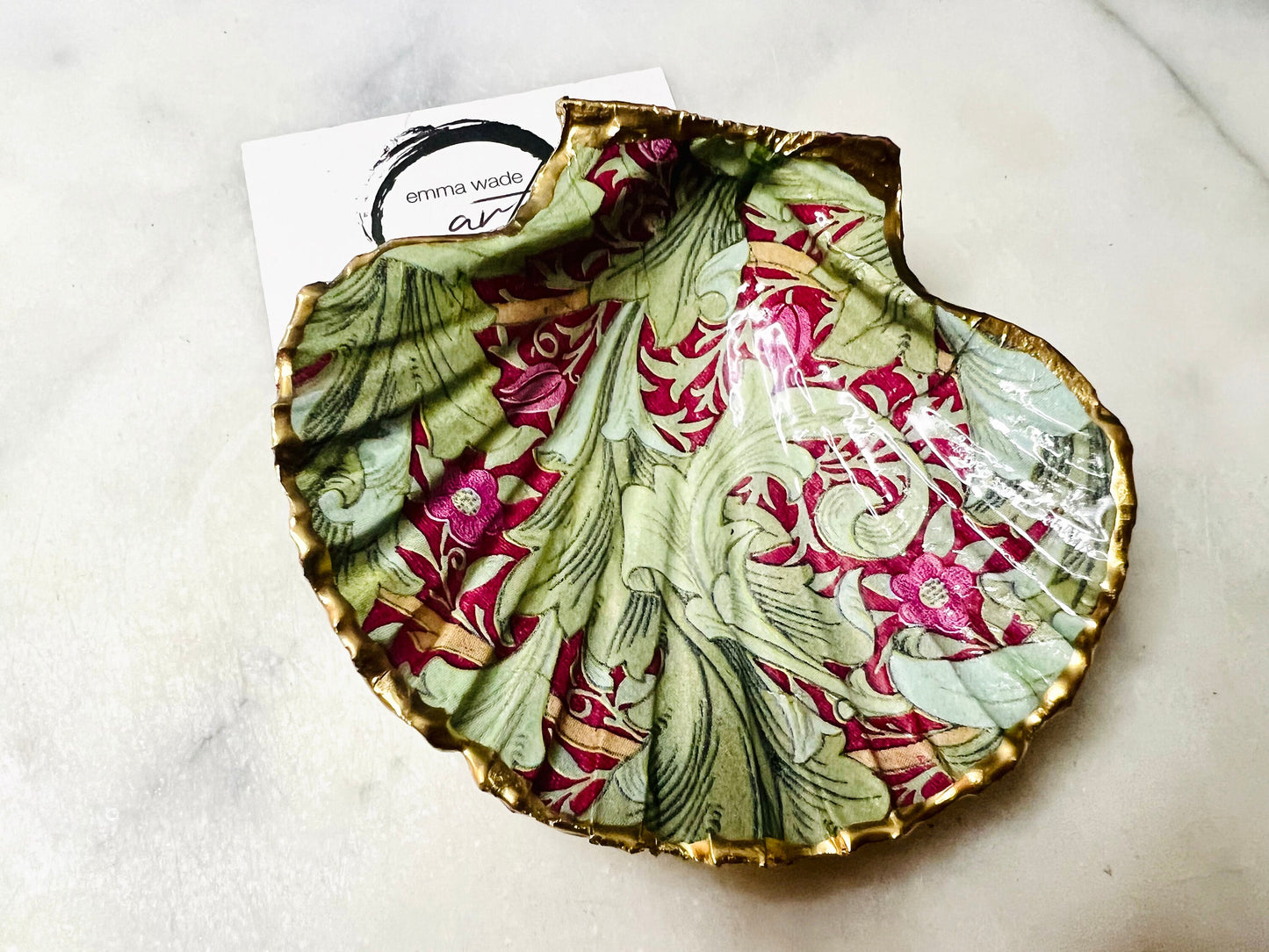 Handmade Dorset scallop shell trinket dish featuring William Morris Granville Bordeaux pattern, finished with real gold leaf edging and a glossy resin coating. A sustainable coastal jewellery dish and ring holder, individually handcrafted in the UK. Ideal as a unique gift for her, wedding or anniversary present, or elegant home décor accent inspired by nature and classic Arts and Crafts design.