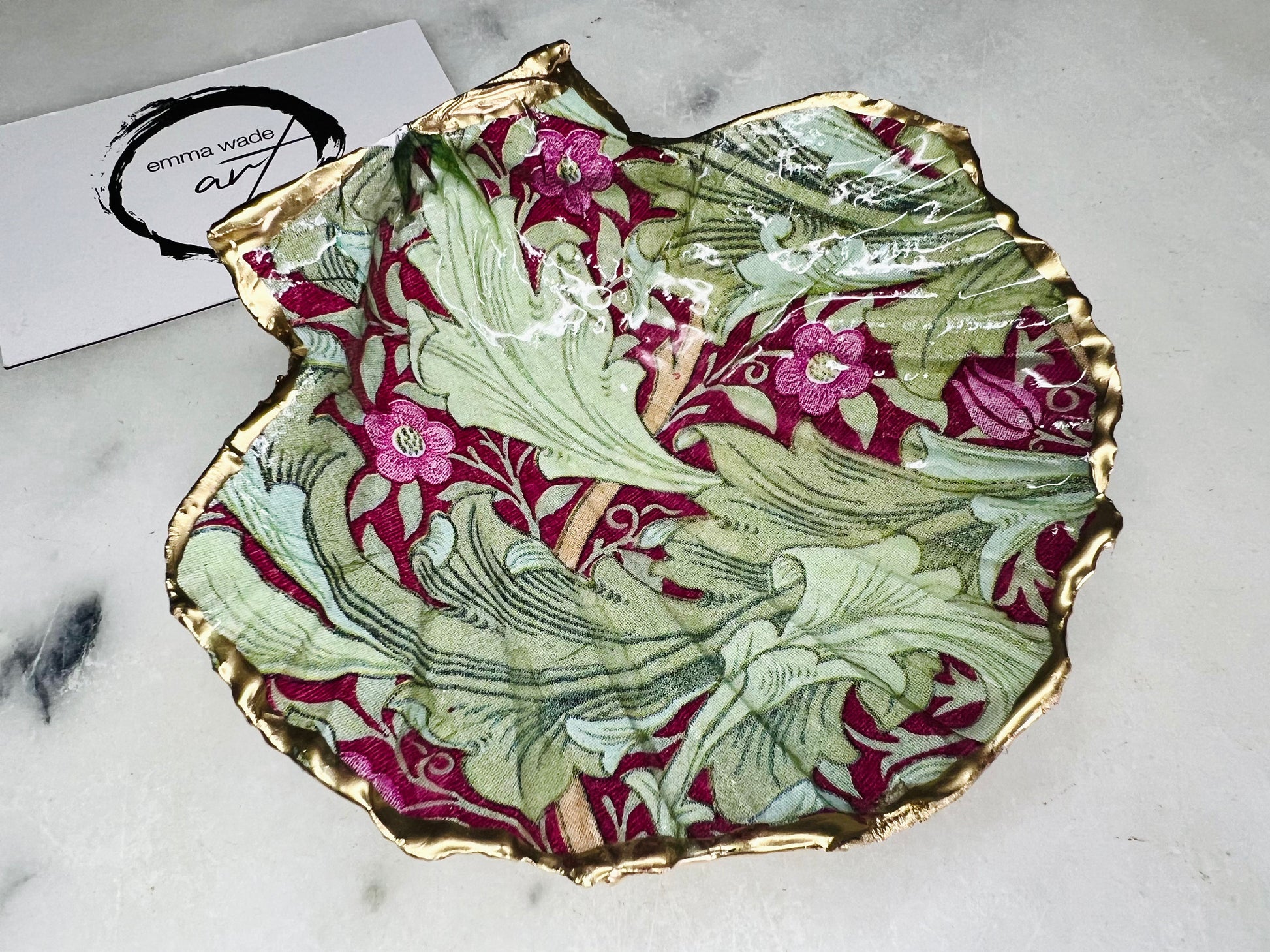 Handmade Dorset scallop shell trinket dish featuring William Morris Granville Bordeaux pattern, finished with real gold leaf edging and a glossy resin coating. A sustainable coastal jewellery dish and ring holder, individually handcrafted in the UK. Ideal as a unique gift for her, wedding or anniversary present, or elegant home décor accent inspired by nature and classic Arts and Crafts design.