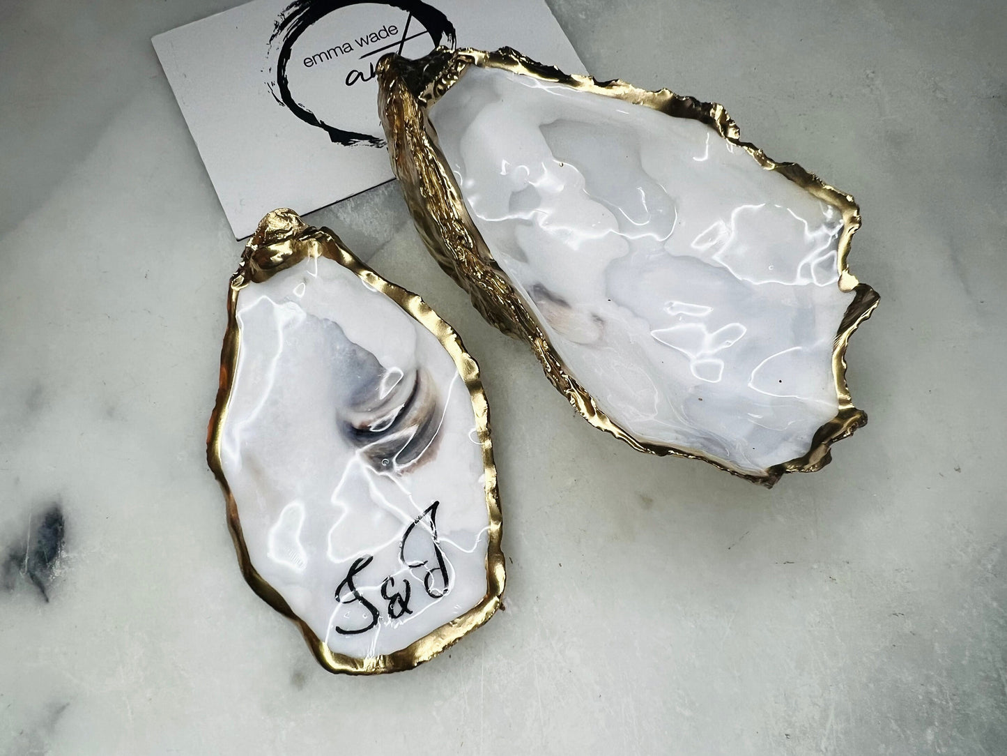 Handmade Dorset oyster shell jewellery dish set with a cupped oyster shell resting on a flat shell base, finished with natural pearl interiors and gold leaf edging. Personalised coastal trinket dish handcrafted in the UK, ideal for holding rings or jewellery. Elegant shell decor presented in sustainable gift packaging, perfect for weddings, anniversaries or special occasions.