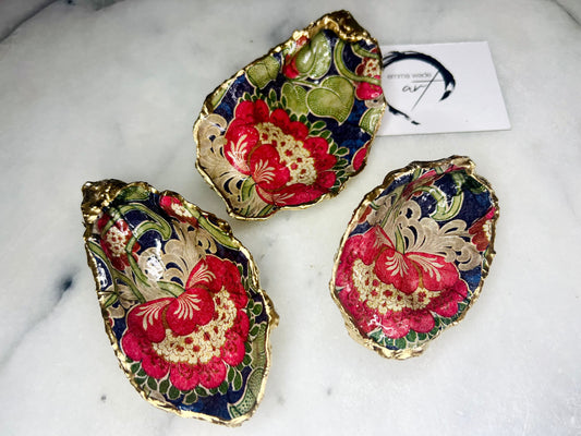 Handmade oyster shell trinket dish featuring a retro floral botanical pattern in pink, red, navy, and olive tones with gold leaf edging and glossy resin finish. Vintage V&A inspired oyster shell jewellery dish styled as coastal cottagecore home décor.