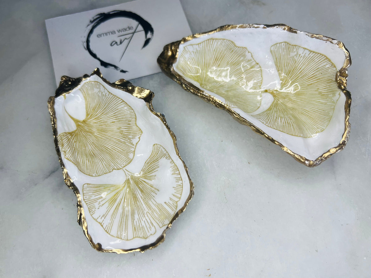 Pair of handmade Dorset oyster shell salt and pepper pinch pots featuring elegant Japanese Ginkgo floral artwork in soft gold and pearl tones with hand-applied gold leaf edging. Coastal luxury cruet set sealed in glossy Crystal resin with optional gold crystal spoons.