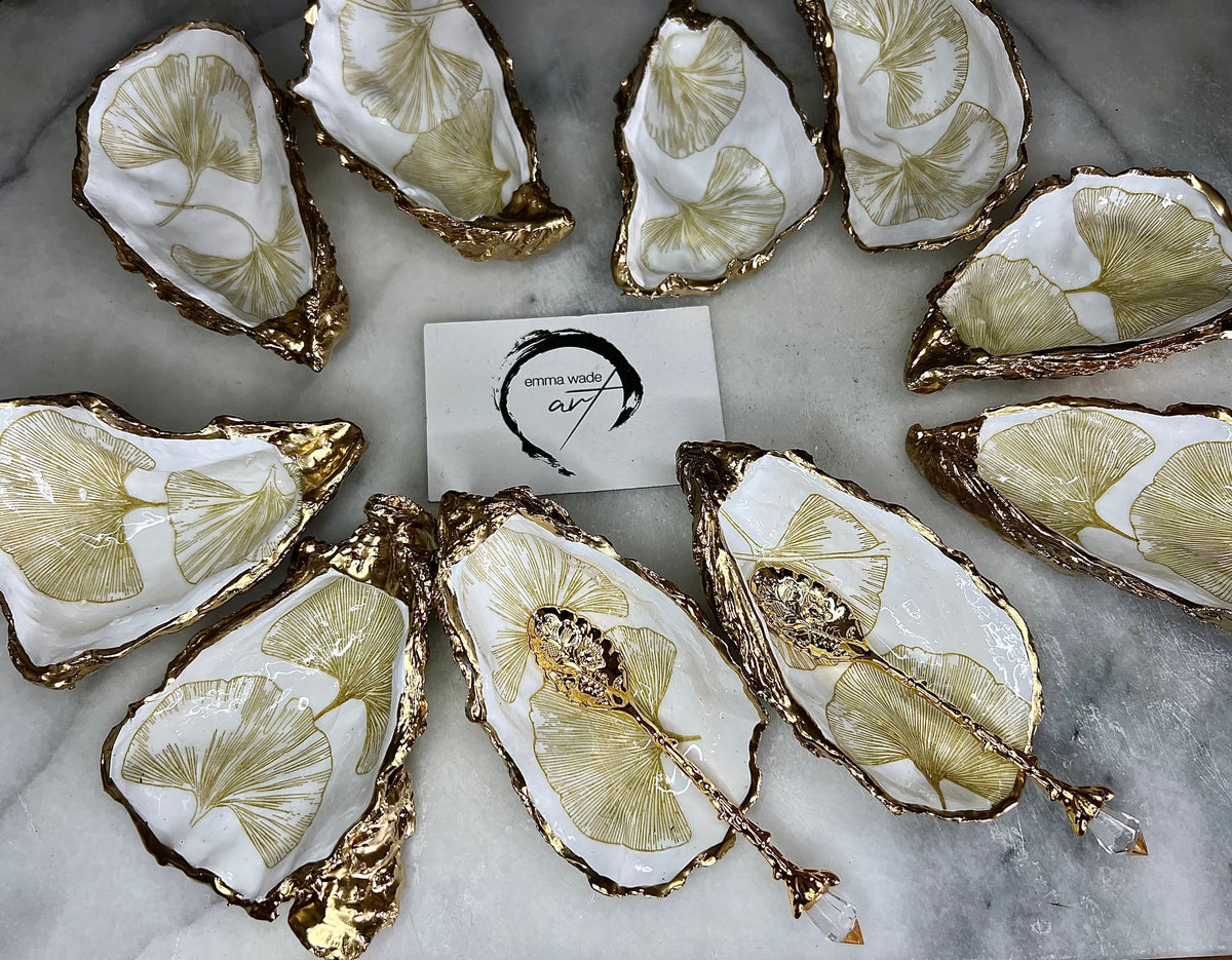 Pair of handmade Dorset oyster shell salt and pepper pinch pots featuring elegant Japanese Ginkgo floral artwork in soft gold and pearl tones with hand-applied gold leaf edging. Coastal luxury cruet set sealed in glossy Crystal resin with optional gold crystal spoons.