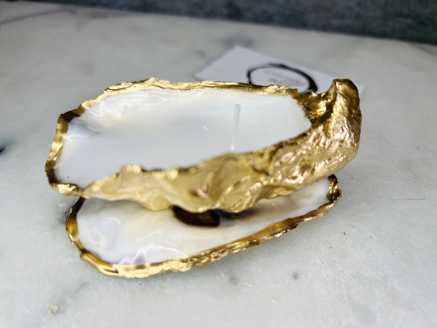 oyster shell candle, gold oyster candle, gilded oyster shells, hand poured candle, coastal decor, ocean inspired candle, beach home decor, sustainable candle, handmade in Surrey, luxury shell candle, sea lover gift, oyster shell pair, artisan candle, eco friendly candle, gold rim shell, nautical decor, ocean gift, coastal homeware, handmade oyster shell candle, shell wedding decor, seaside candle, mother of pearl shell, gold edged candle, beach cottage style, elegant coastal gift