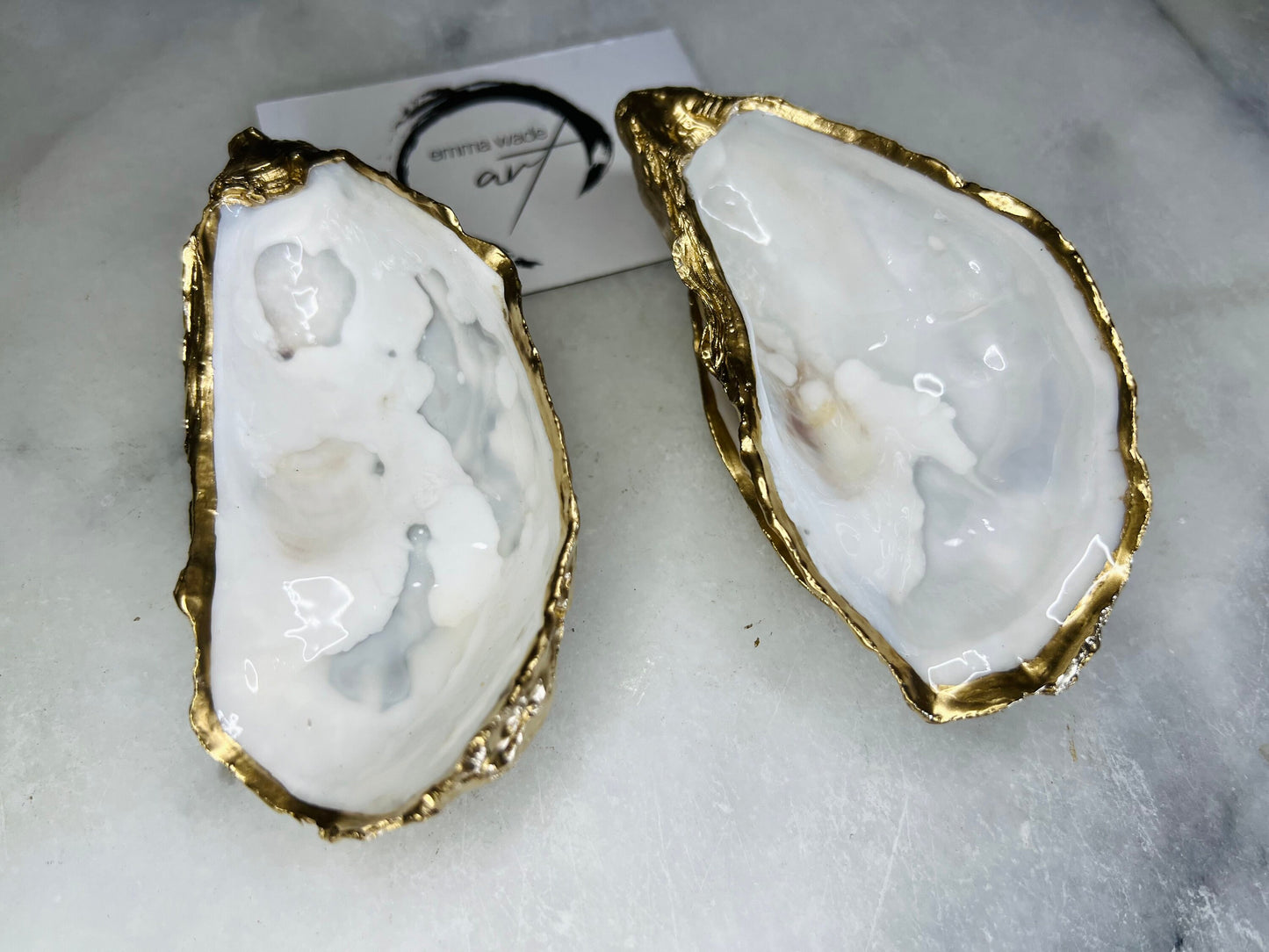 Handmade Dorset oyster shell jewellery dish set with a cupped oyster shell resting on a flat shell base, finished with natural pearl interiors and gold leaf edging. Personalised coastal trinket dish handcrafted in the UK, ideal for holding rings or jewellery. Elegant shell decor presented in sustainable gift packaging, perfect for weddings, anniversaries or special occasions.