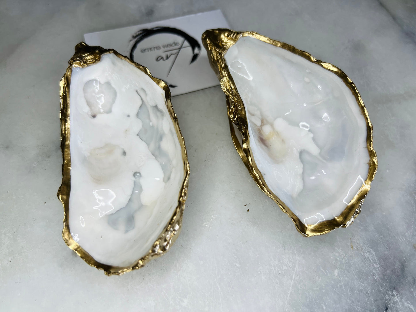 Handmade Dorset oyster shell jewellery dish set with a cupped oyster shell resting on a flat shell base, finished with natural pearl interiors and gold leaf edging. Personalised coastal trinket dish handcrafted in the UK, ideal for holding rings or jewellery. Elegant shell decor presented in sustainable gift packaging, perfect for weddings, anniversaries or special occasions.