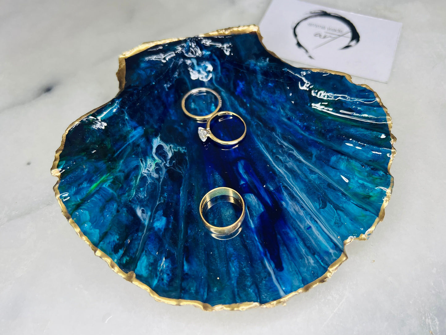 Extra large hand-painted Dorset scallop shell trinket dish featuring deep blue ocean-inspired resin artwork with turquoise wave details, hand gilded gold edging, glossy coastal jewellery holder and luxury seaside décor
