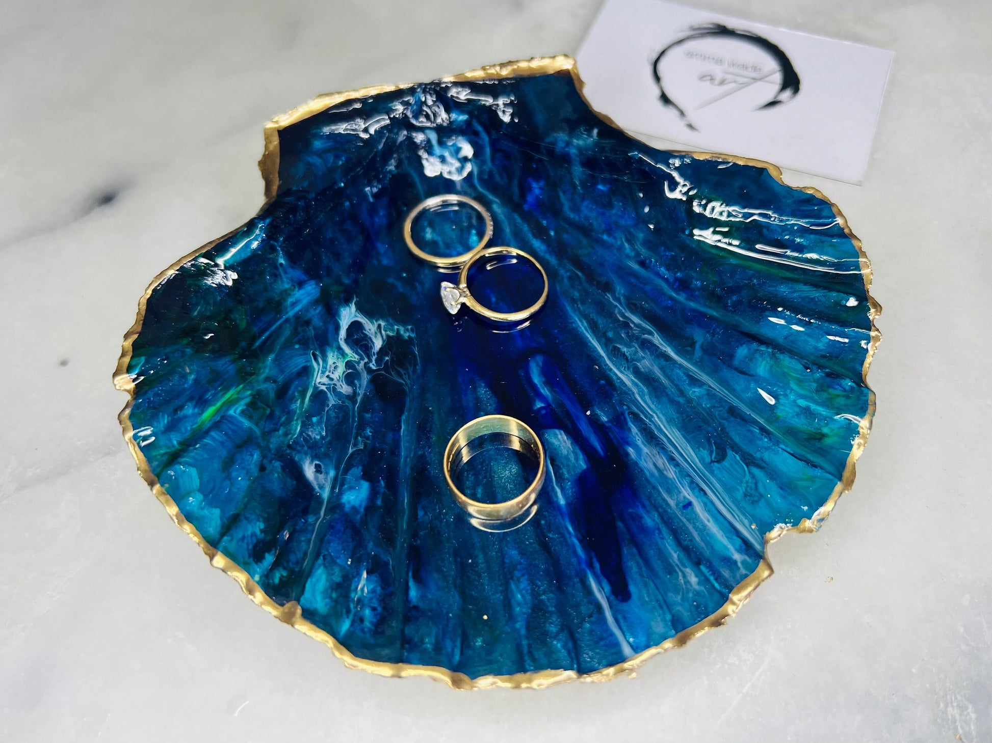 Extra large hand-painted Dorset scallop shell trinket dish featuring deep blue ocean-inspired resin artwork with turquoise wave details, hand gilded gold edging, glossy coastal jewellery holder and luxury seaside décor