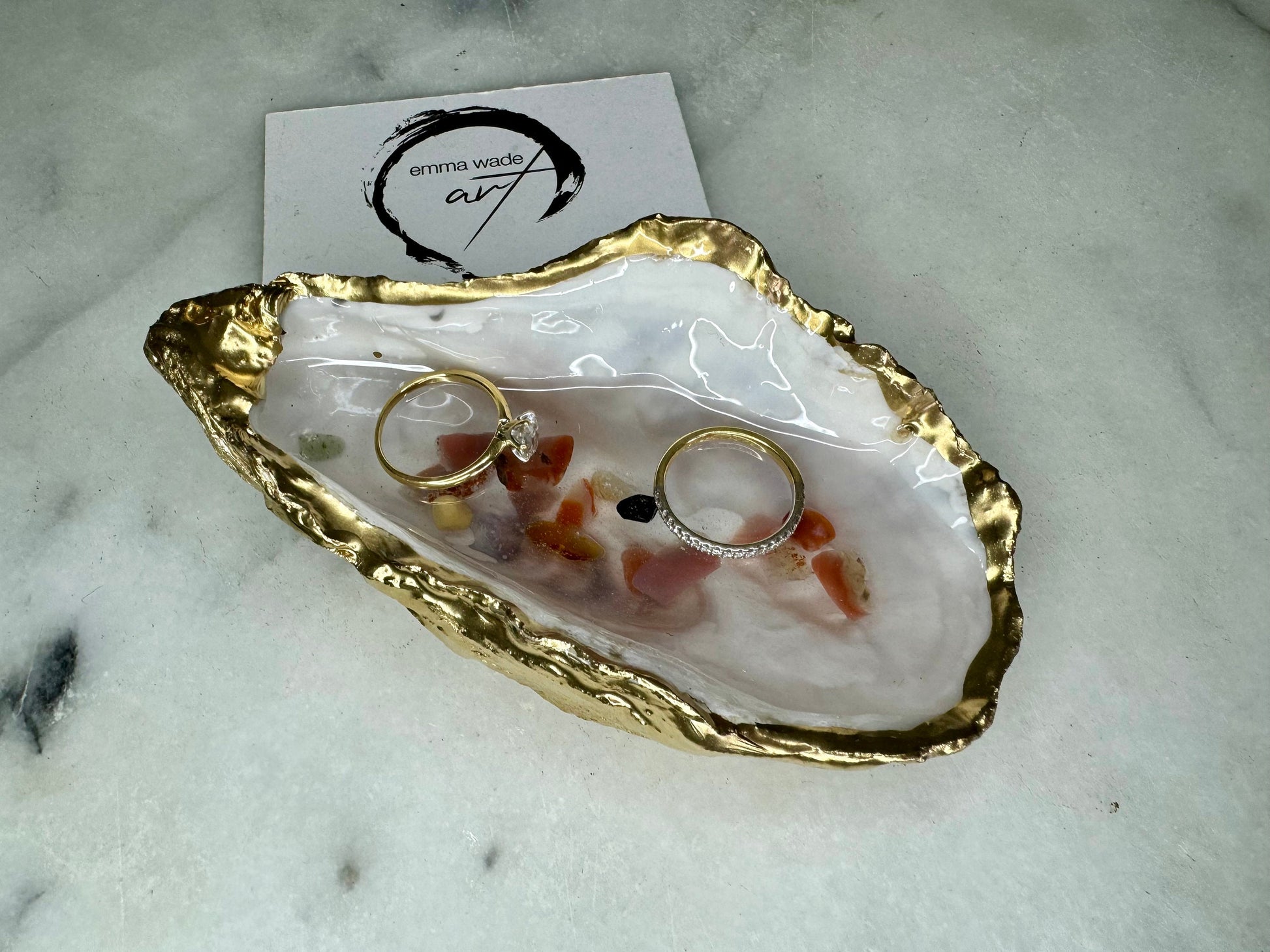 Handmade oyster shell jewellery dish with real Dorset sea glass foraged from the coast and suspended in clear glossy resin to look like a rock pool. Finished with gold leaf trim and a natural pearl interior, this unique shell dish can be used as a ring holder, jewellery tray, or trinket catcher for earrings, cufflinks, or keepsakes. A one-of-a-kind coastal-inspired gift for weddings, anniversaries, birthdays, bridesmaids, Christmas, or Mother’s Day.