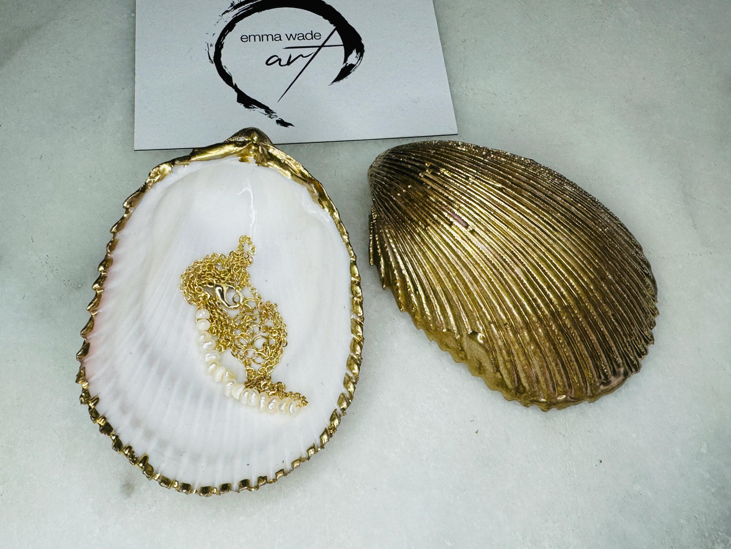 Handmade gold gilded cockle shell jewellery box with pearly white interior and optional freshwater pearl necklace. Coastal shell ring box crafted from natural Dorset shells, edged with liquid gold leaf and presented in a luxury gift box. Elegant seaside-inspired keepsake gift for weddings, bridesmaids, birthdays, anniversaries, or jewellery storage.