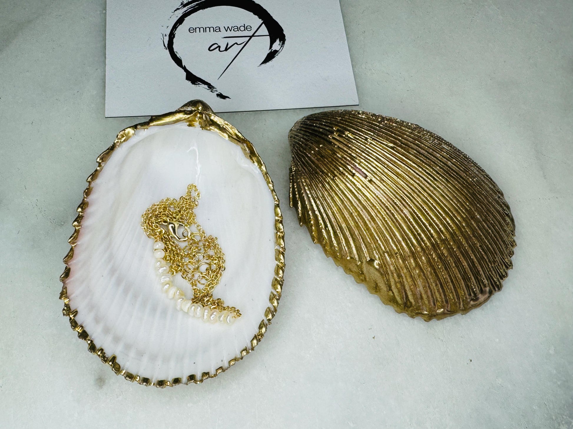 Handmade gold gilded cockle shell jewellery box with pearly white interior and optional freshwater pearl necklace. Coastal shell ring box crafted from natural Dorset shells, edged with liquid gold leaf and presented in a luxury gift box. Elegant seaside-inspired keepsake gift for weddings, bridesmaids, birthdays, anniversaries, or jewellery storage.
