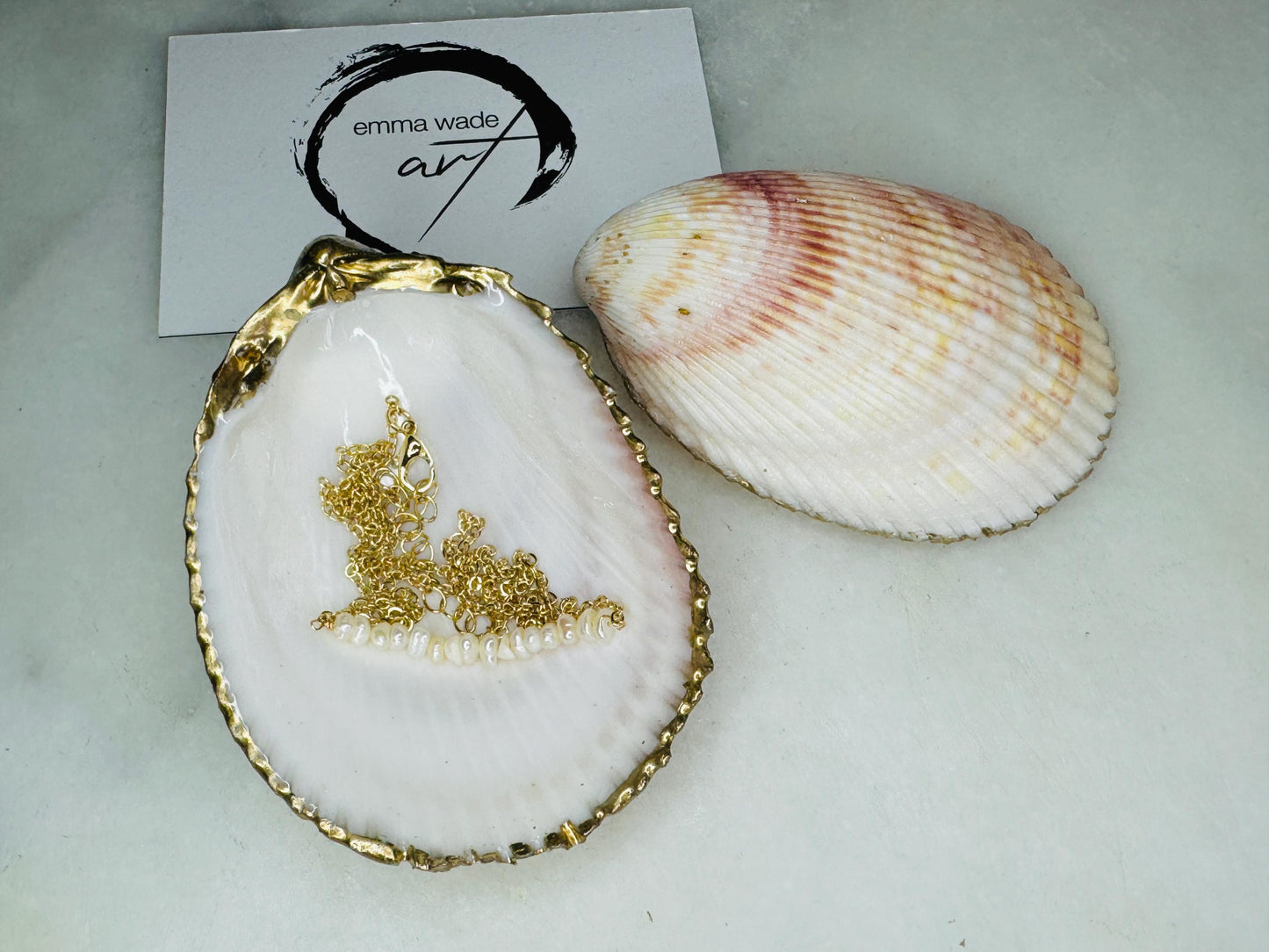 Handmade gold gilded cockle shell jewellery box with pearly white interior and optional freshwater pearl necklace. Coastal shell ring box crafted from natural Dorset shells, edged with liquid gold leaf and presented in a luxury gift box. Elegant seaside-inspired keepsake gift for weddings, bridesmaids, birthdays, anniversaries, or jewellery storage.