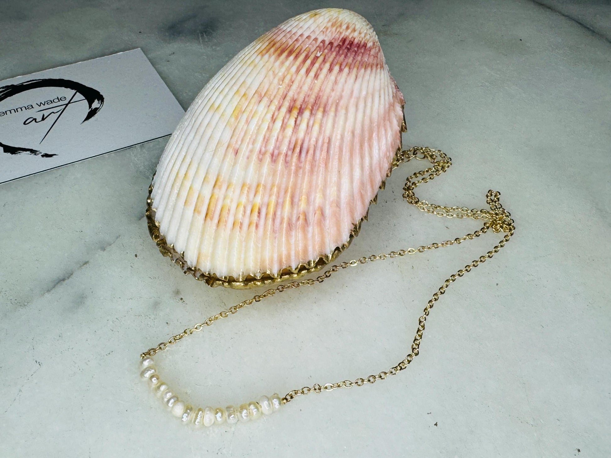 Handmade gold gilded cockle shell jewellery box with pearly white interior and optional freshwater pearl necklace. Coastal shell ring box crafted from natural Dorset shells, edged with liquid gold leaf and presented in a luxury gift box. Elegant seaside-inspired keepsake gift for weddings, bridesmaids, birthdays, anniversaries, or jewellery storage.