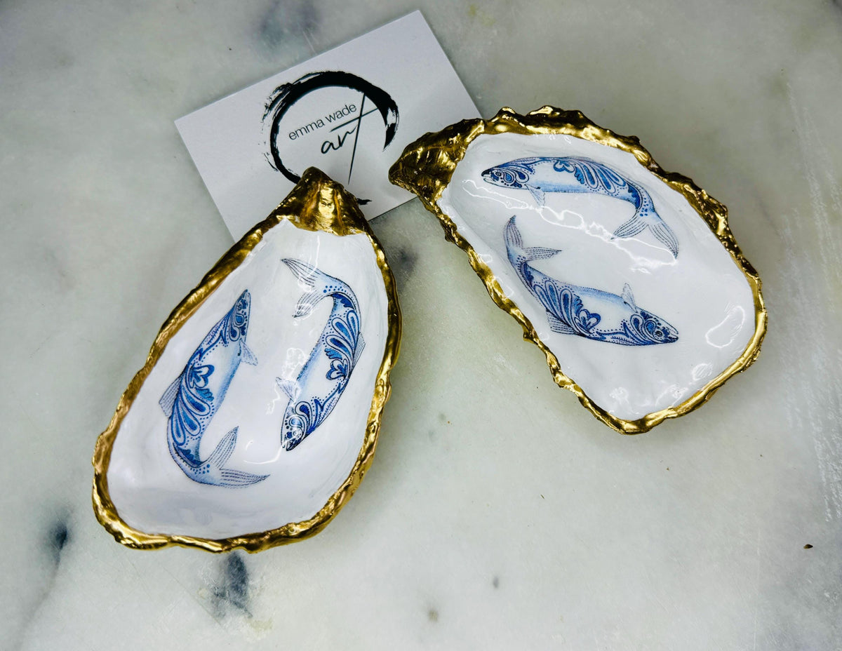 Handmade Dorset oyster shell salt and pepper pinch pots featuring blue paisley fish designs with gold leaf edging and glossy resin finish. Coastal oyster shell cruet set with natural pearlescent interiors and optional gold spoons, styled as elegant nautical table décor and condiment dishes.