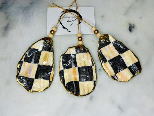 Black and Gold Oyster Shell Hanging Ornament, handmade from Dorset oysters, decoupaged and gilded with liquid gold leaf and sealed with gloss resin. Unique shell Christmas decoration, nautical ornament, chess chequer inspired design. Available individually or as a set of 3. Perfect eco friendly coastal gift, oyster shell bauble, luxury holiday decoration, ocean inspired home décor, handmade oyster art, and nature lover gift.