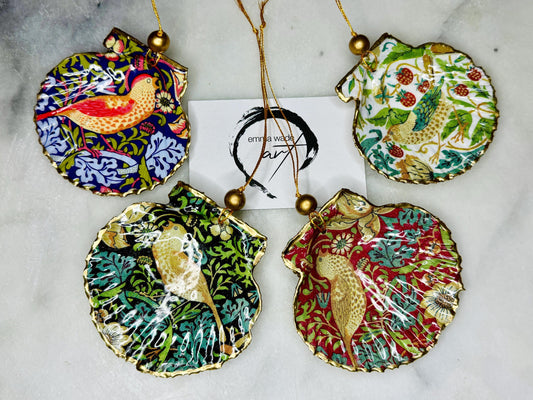 Handmade William Morris Strawberry Thief scallop shell hanging ornaments in four colourways with birds, floral patterns and gold leaf edging. Coastal shell ornaments finished in glossy resin with gold hanging cords for Christmas trees or year-round home decor.