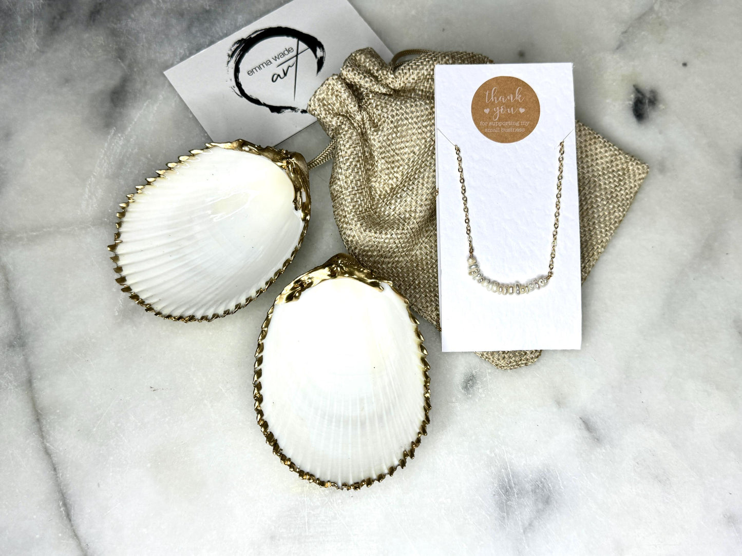 Handmade gold gilded cockle shell jewellery box with pearly white interior and optional freshwater pearl necklace. Coastal shell ring box crafted from natural Dorset shells, edged with liquid gold leaf and presented in a luxury gift box. Elegant seaside-inspired keepsake gift for weddings, bridesmaids, birthdays, anniversaries, or jewellery storage.