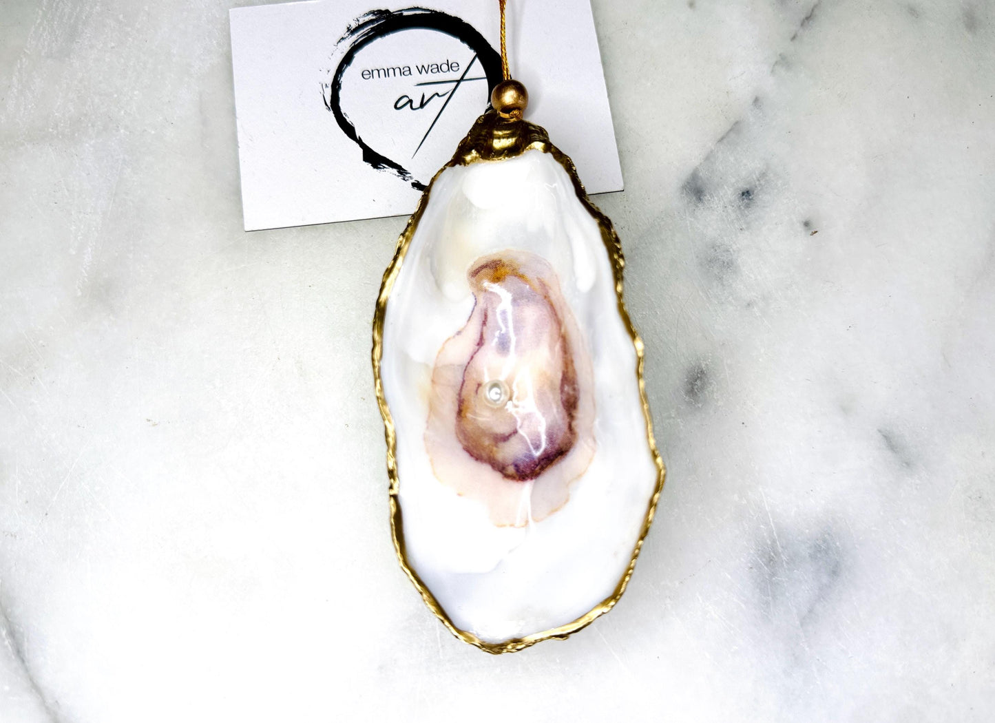 Handmade Dorset oyster shell jewellery dish with a natural pearl finish, gilded with liquid gold leaf and sealed in glossy resin. Each oyster shell features a Swarovski pearl inside, making it a unique ring holder, trinket tray, or coastal-inspired jewellery organiser. Perfect as a handmade oyster ring dish for weddings, anniversaries, birthdays, or as a bridesmaid gift. A one-of-a-kind shell catchall tray, ideal for coastal home décor or thoughtful handmade presents.