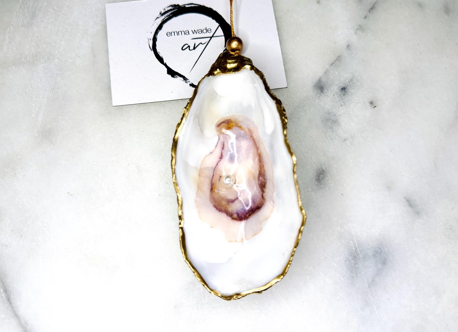 Handmade Dorset oyster shell jewellery dish with a natural pearl finish, gilded with liquid gold leaf and sealed in glossy resin. Each oyster shell features a Swarovski pearl inside, making it a unique ring holder, trinket tray, or coastal-inspired jewellery organiser. Perfect as a handmade oyster ring dish for weddings, anniversaries, birthdays, or as a bridesmaid gift. A one-of-a-kind shell catchall tray, ideal for coastal home décor or thoughtful handmade presents.