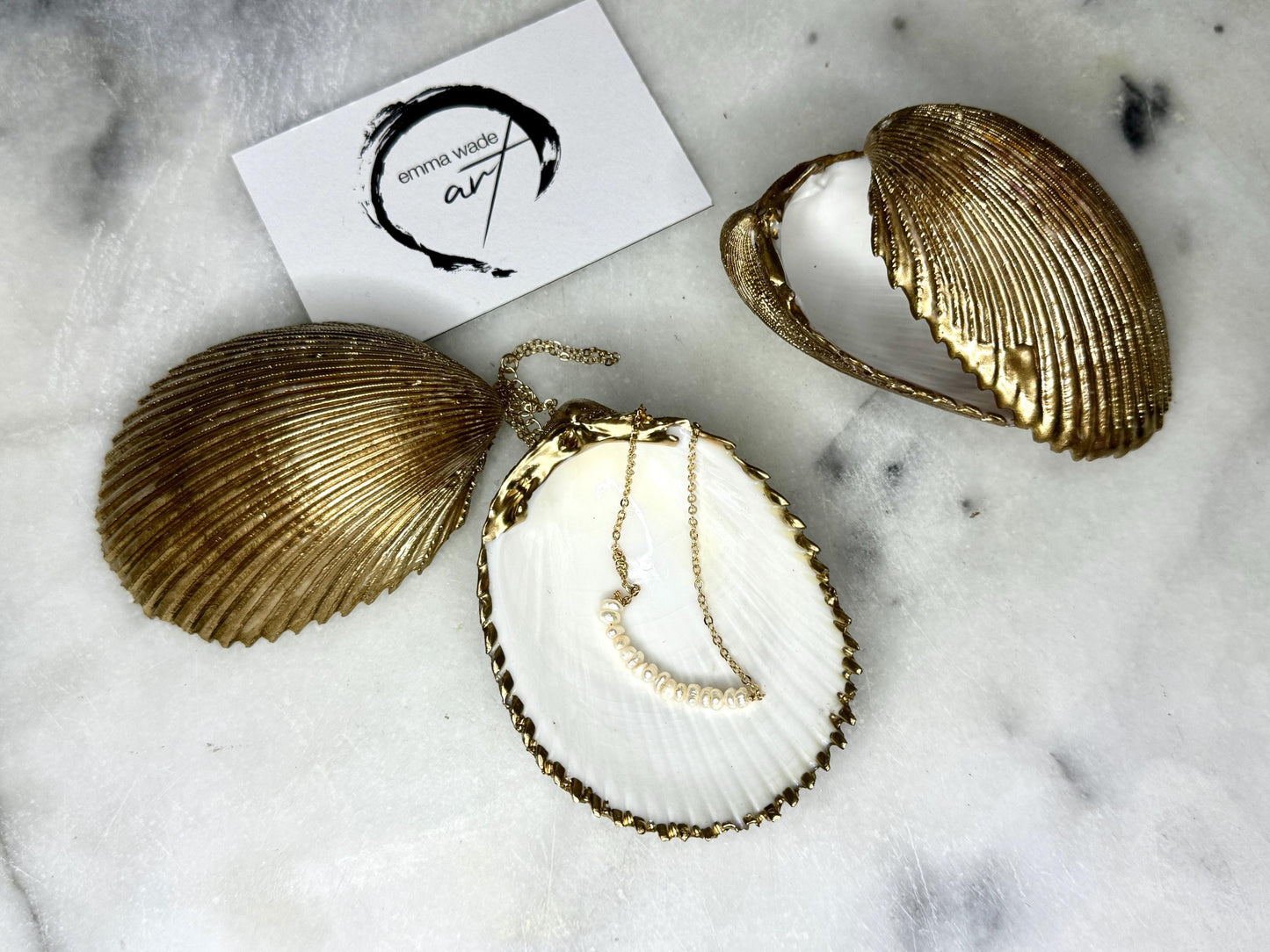 Handmade gold gilded cockle shell jewellery box with pearly white interior and optional freshwater pearl necklace. Coastal shell ring box crafted from natural Dorset shells, edged with liquid gold leaf and presented in a luxury gift box. Elegant seaside-inspired keepsake gift for weddings, bridesmaids, birthdays, anniversaries, or jewellery storage.