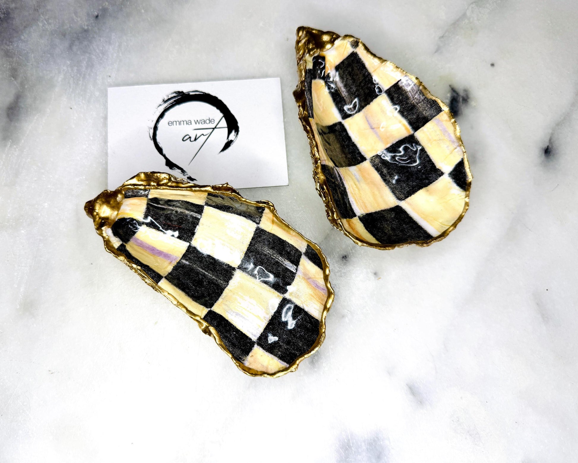 Black and gold chequered oyster shell dish with liquid gold leaf edging and glossy resin finish. A unique oyster ring dish, oyster ring tray, or shell jewellery organiser for rings, earrings, and cufflinks. This handmade trinket tray doubles as a jewellery dish or decorative coastal accent. Crafted from Dorset shells, each piece is one of a kind. A thoughtful handmade gift for weddings, anniversaries, birthdays, Christmas, bridesmaids, or new home celebrations.