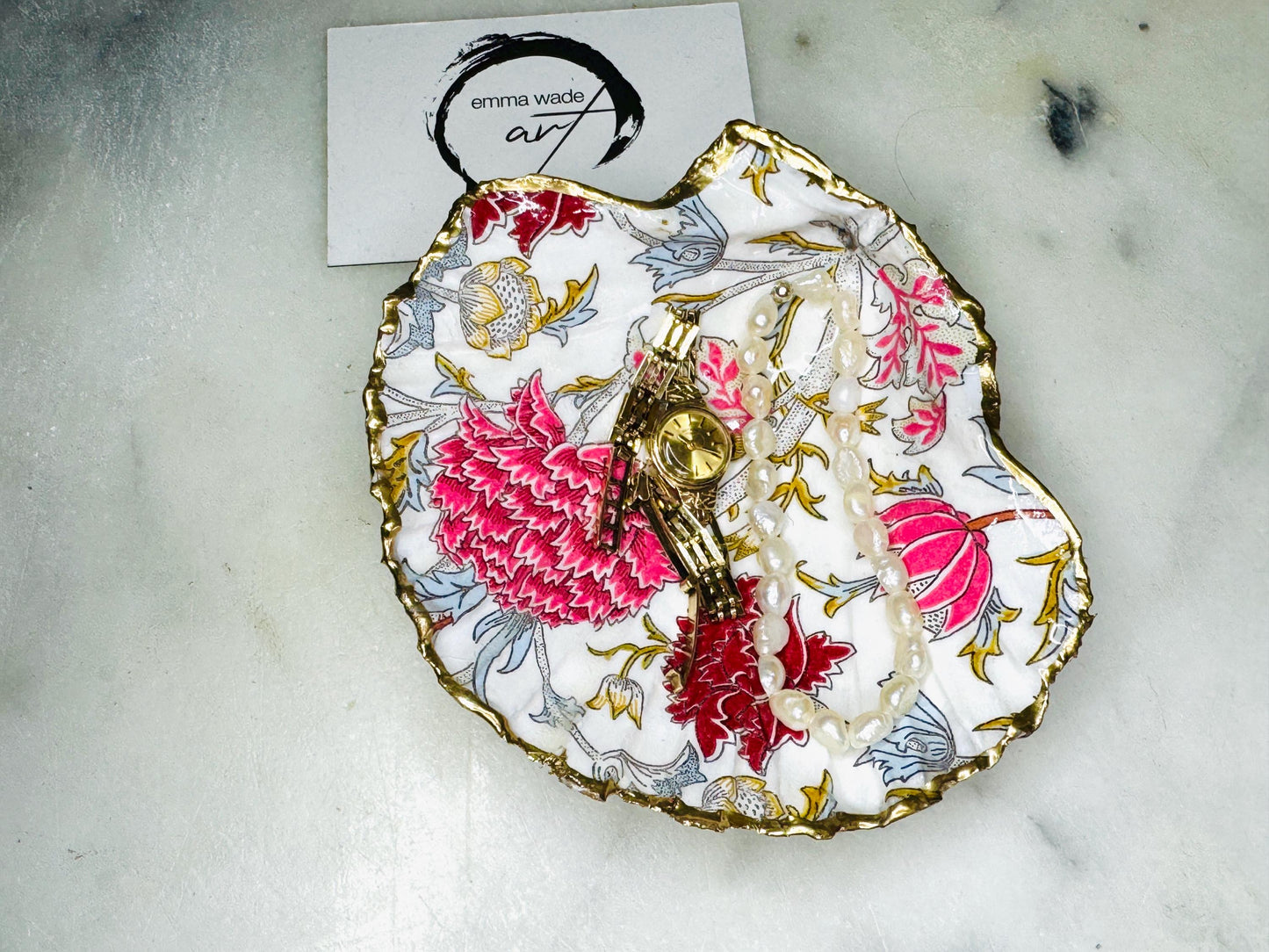 Handcrafted Dorset scallop shell trinket dish featuring William Morris Cray floral design in pink and red botanical patterns with hand gilded gold leaf edging and glossy resin finish. English cottage style jewellery dish and coastal heritage décor piece styled as a luxury shell tray.