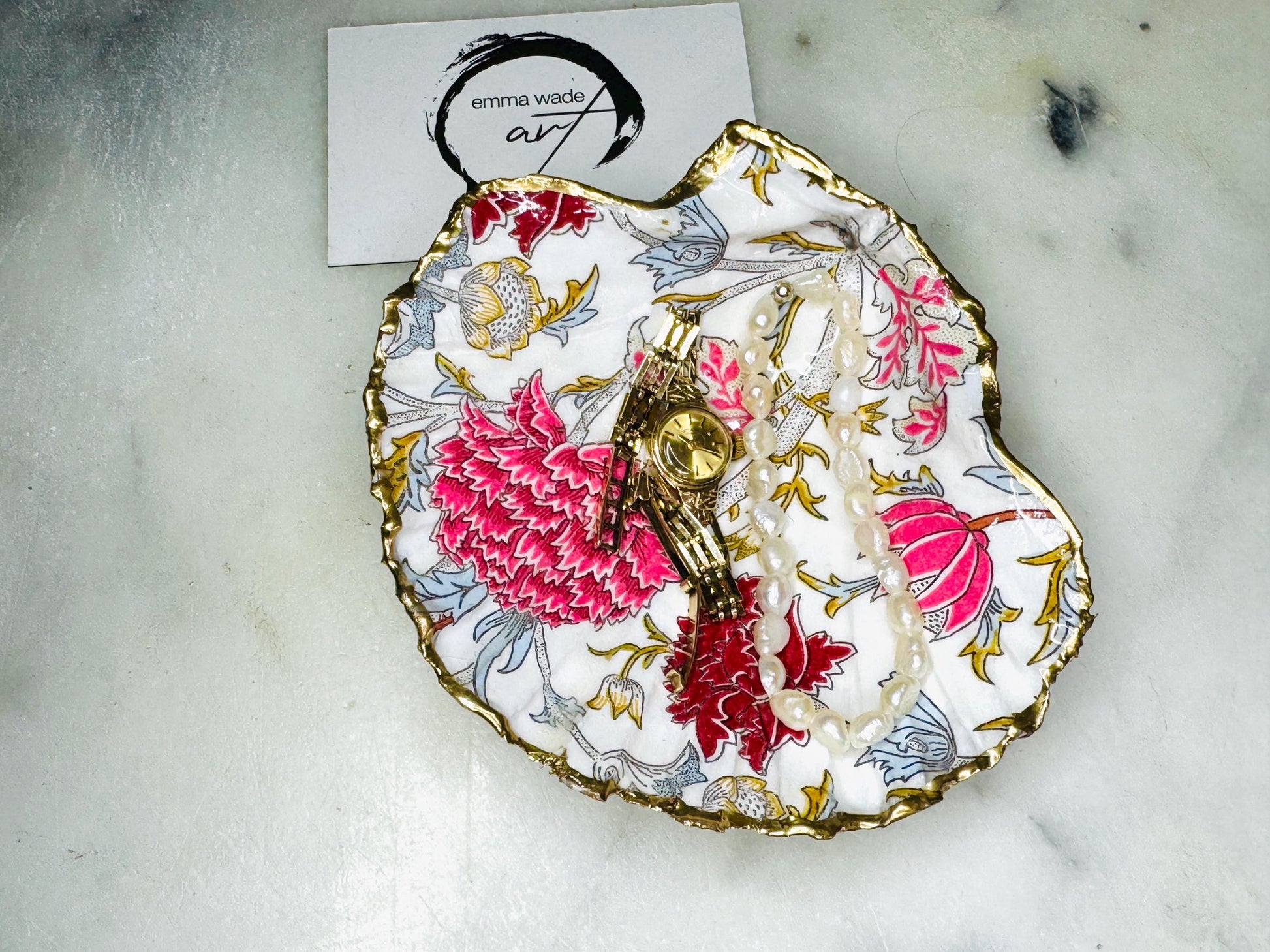 Handcrafted Dorset scallop shell trinket dish featuring William Morris Cray floral design in pink and red botanical patterns with hand gilded gold leaf edging and glossy resin finish. English cottage style jewellery dish and coastal heritage décor piece styled as a luxury shell tray.