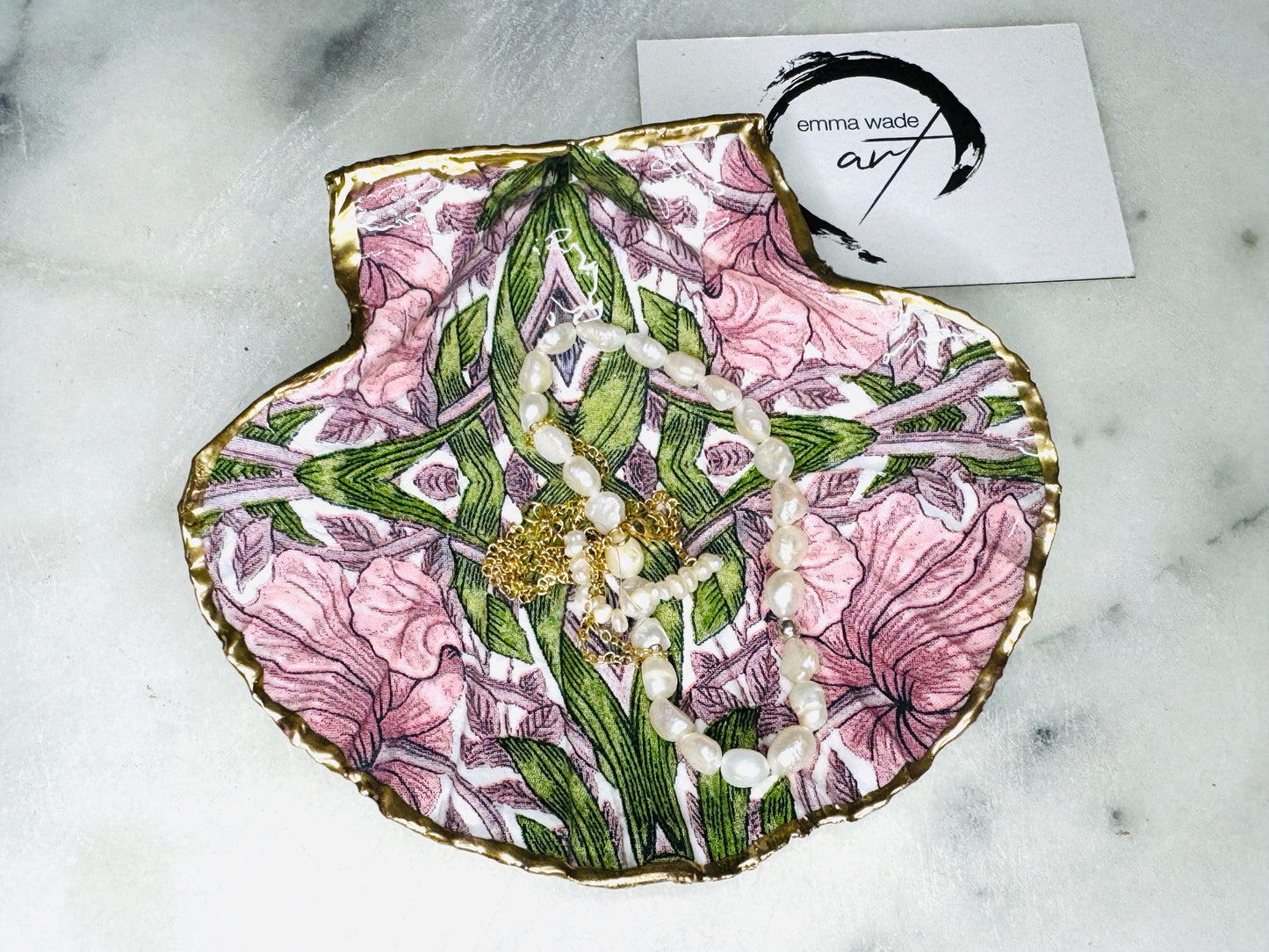 William Morris inspired scallop shell trinket dish featuring the iconic Pimpernel floral pattern in pink and green tones. Handcrafted using sustainably sourced Dorset scallop shells, hand gilded with real liquid gold leaf and sealed with crystal-clear hard resin. Luxury coastal jewellery dish, ring holder, trinket tray, or decorative Arts & Crafts gift available in two sizes.