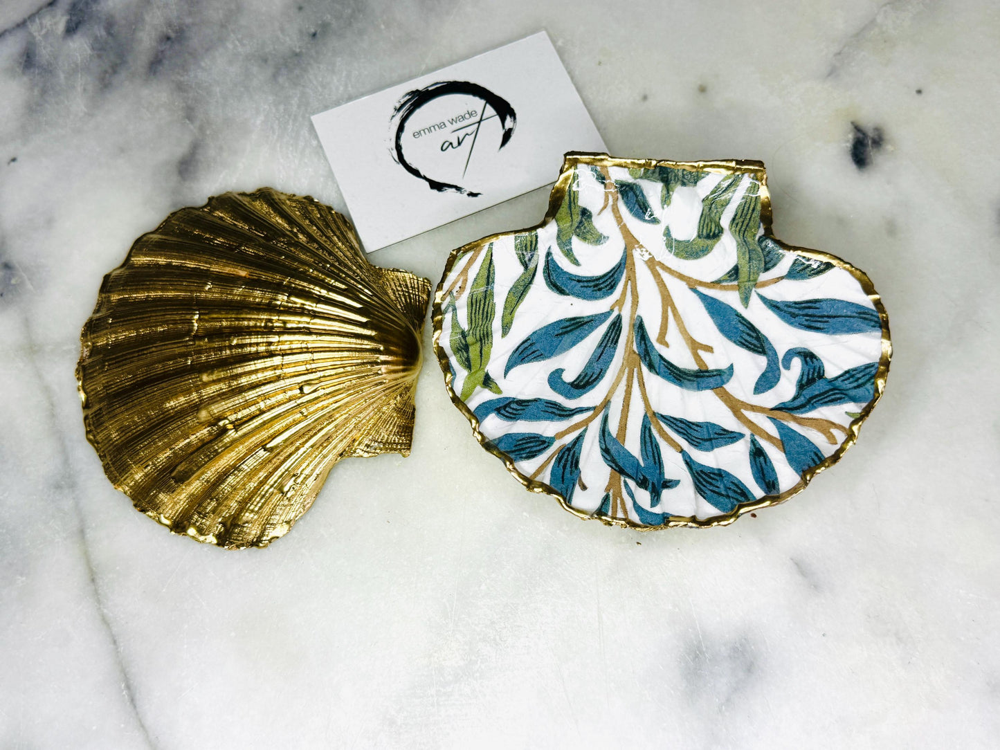Handmade Dorset scallop shell trinket dish featuring William Morris Willow Bough design in soft blue and green tones. Decorative shell jewellery dish finished with hand-applied liquid gold leaf edging and glossy resin. Coastal inspired ring holder with botanical Arts and Crafts pattern and natural shell shape, styled as elegant bathroom décor and heritage home accessory.