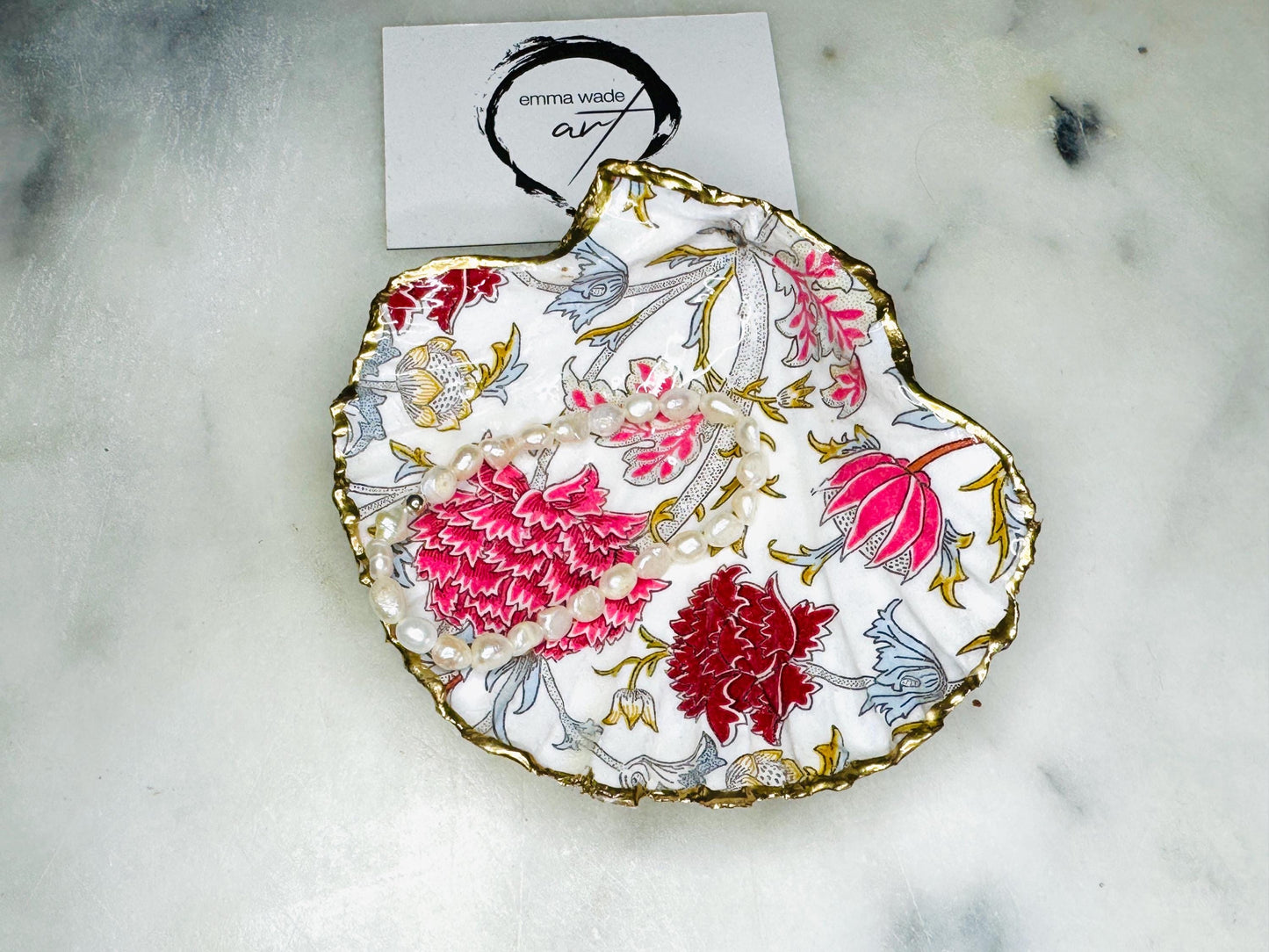 Handcrafted Dorset scallop shell trinket dish featuring William Morris Cray floral design in pink and red botanical patterns with hand gilded gold leaf edging and glossy resin finish. English cottage style jewellery dish and coastal heritage décor piece styled as a luxury shell tray.